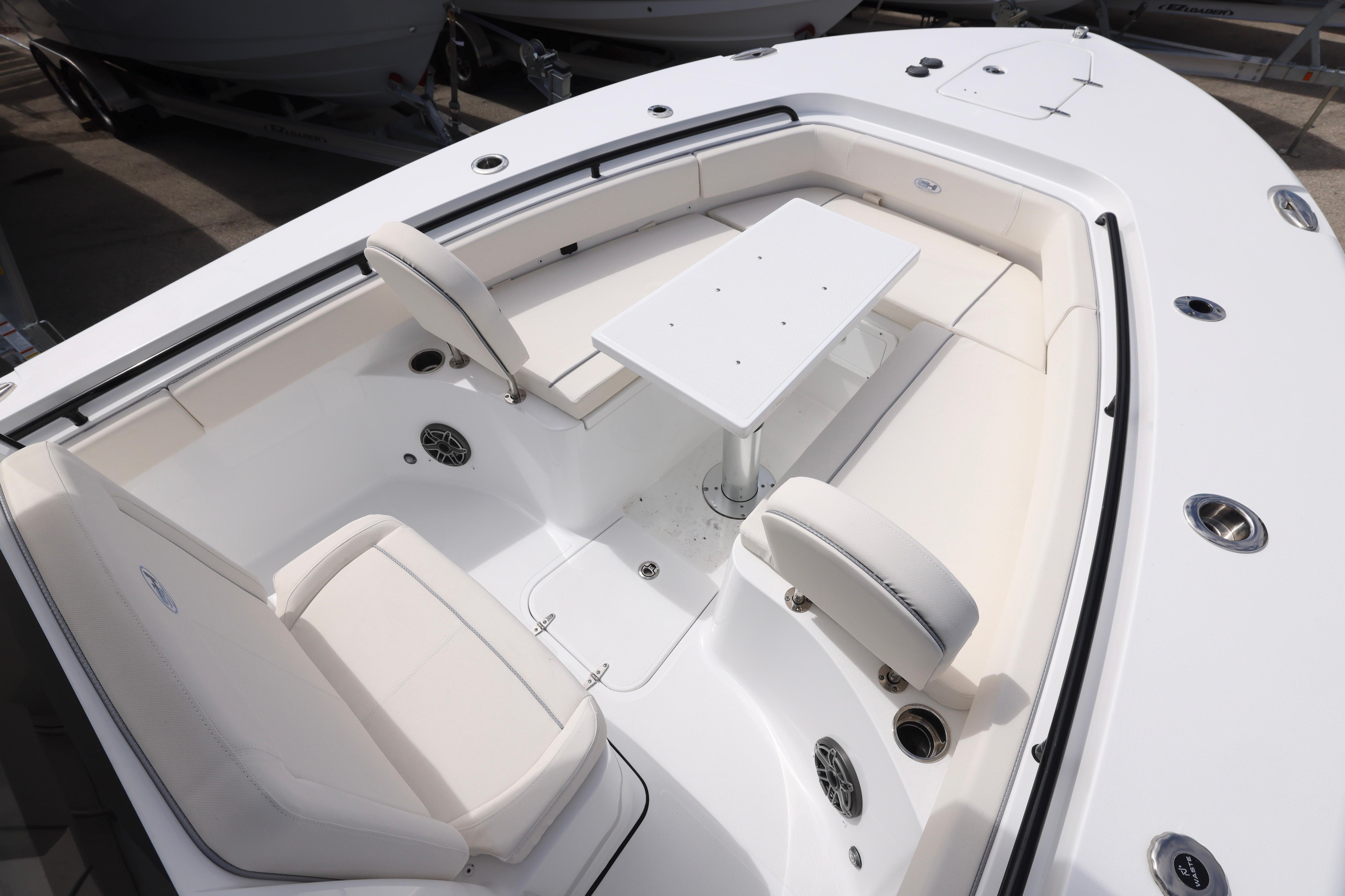 2026 Sea Hunt Gamefish 25 boat interior with white seating and table setup.