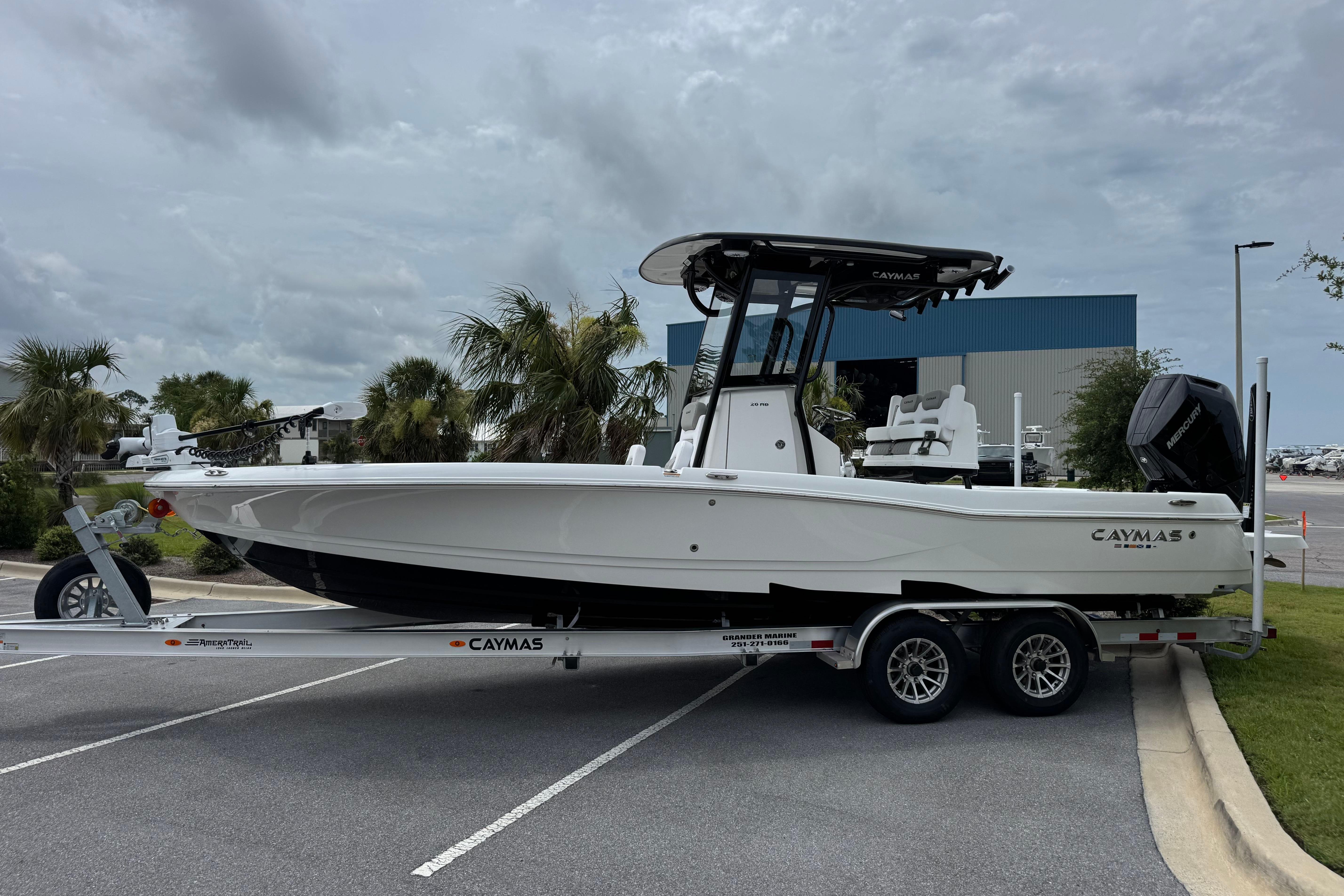 2027 Caymas 26 HB boat on trailer, parked outdoors under cloudy sky.