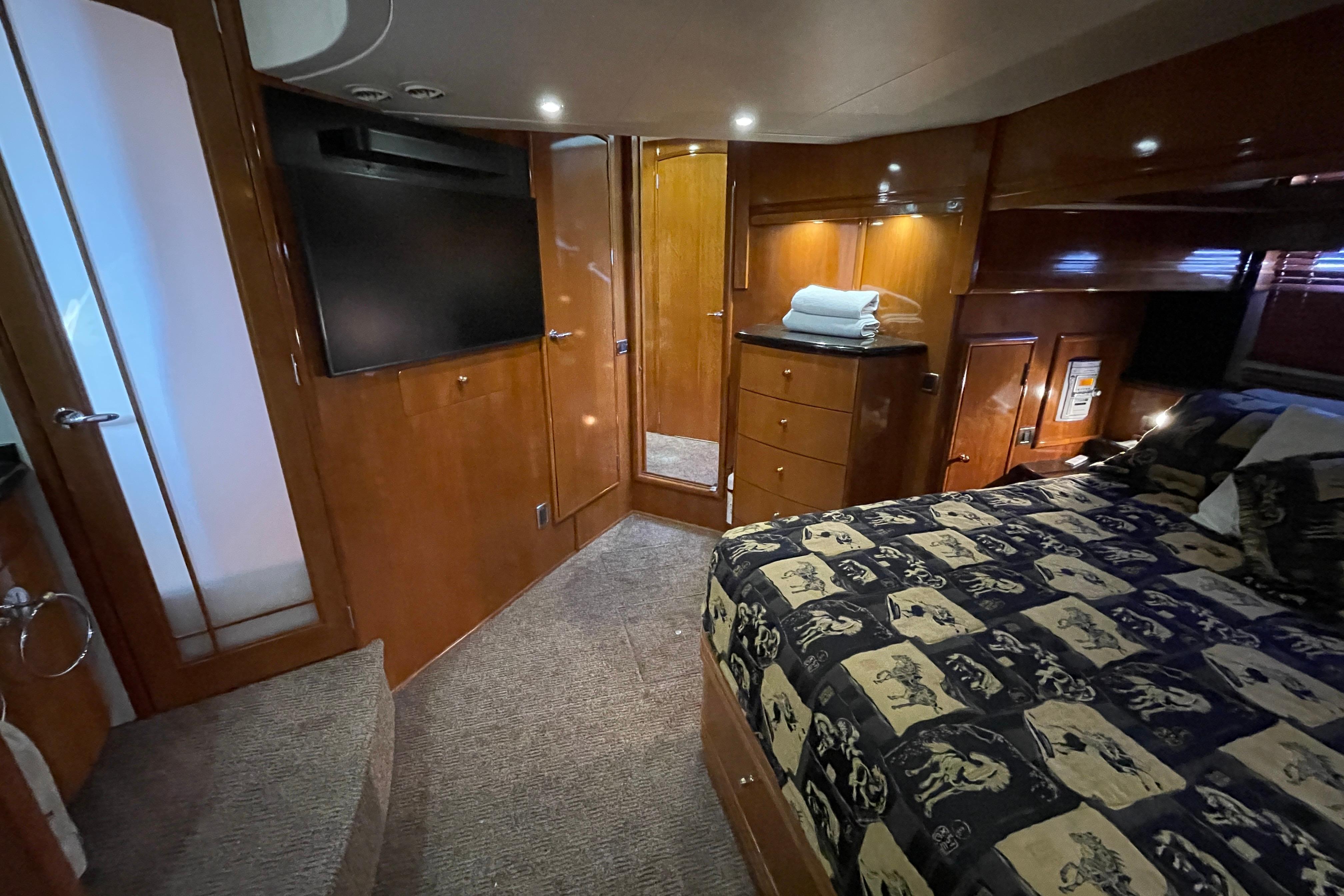 Luxurious interior of 2002 Carver 570 Voyager Pilothouse with wood finishes and cozy bedding.