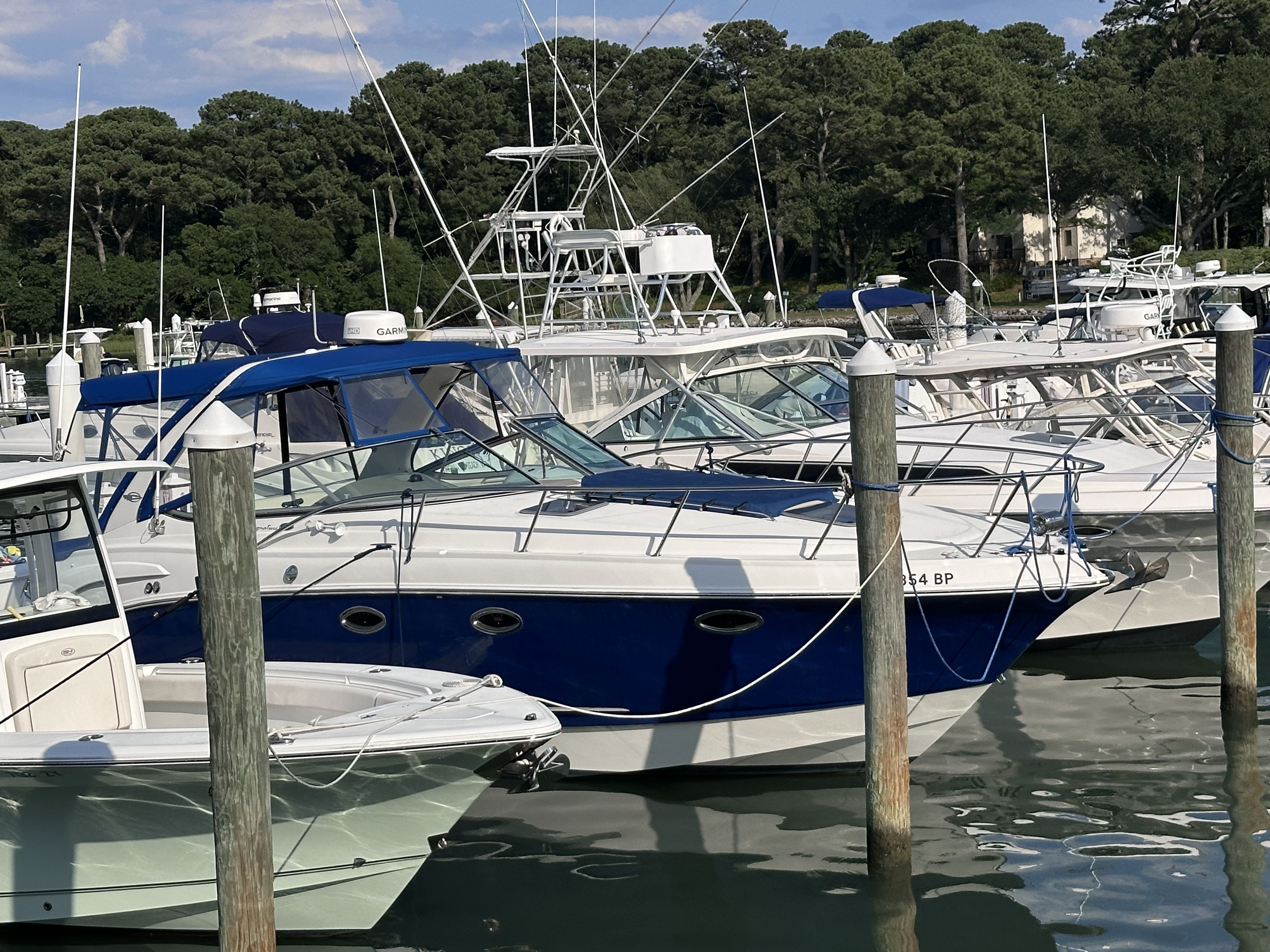A 2008 Chaparral Signature 330 docked in a marina. It features a blue canopy and white details.