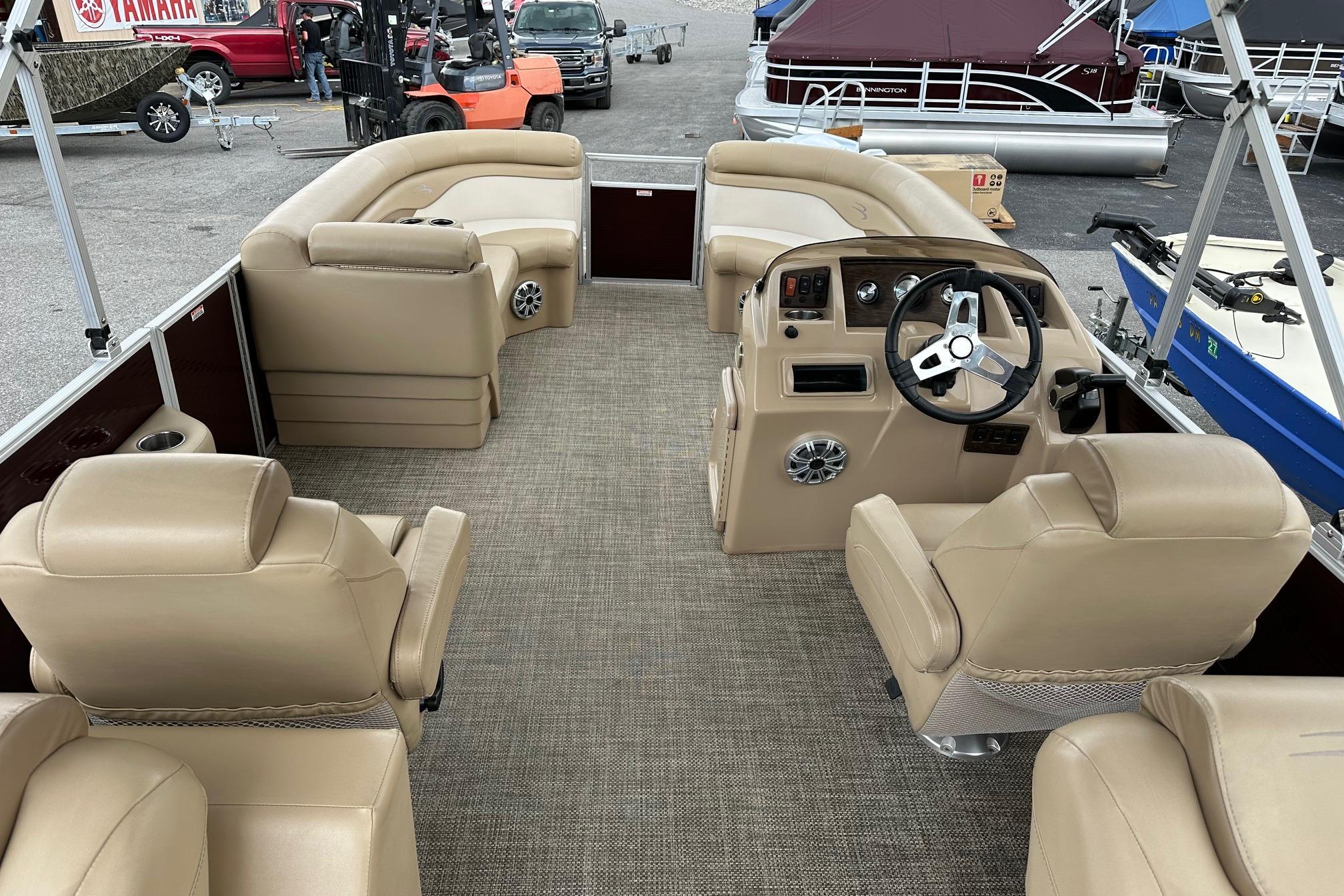 2016 Bennington 24 SCWX pontoon boat interior with beige seating and steering console.