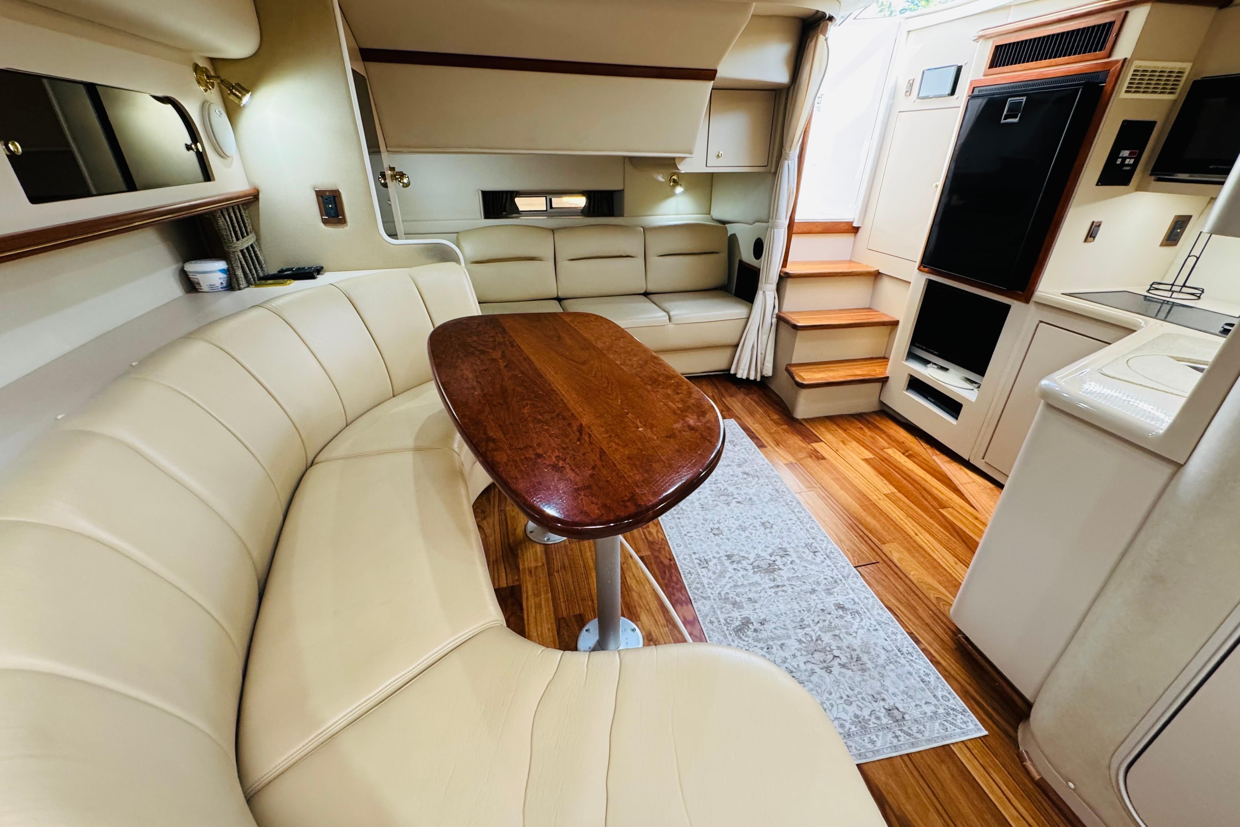 Interior of 2000 Cruisers Yachts 3575 Express with elegant seating and wooden table.