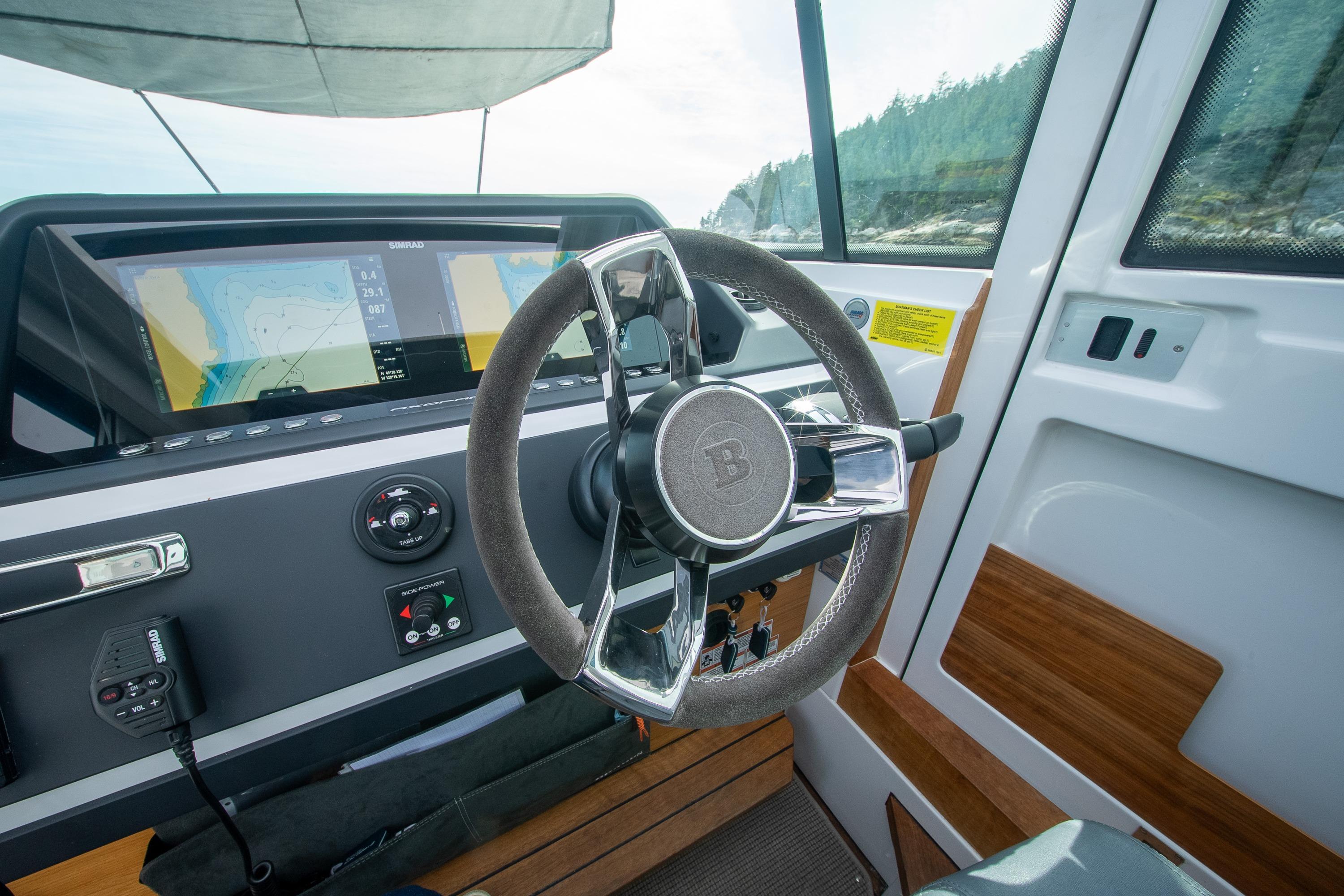 2021 Axopar 28 Cabin helm with modern navigation system and sleek steering wheel.