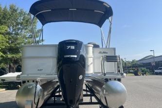 2026 Sun Tracker Party Barge 18 DLX pontoon boat with 75 HP engine, docked outdoors.