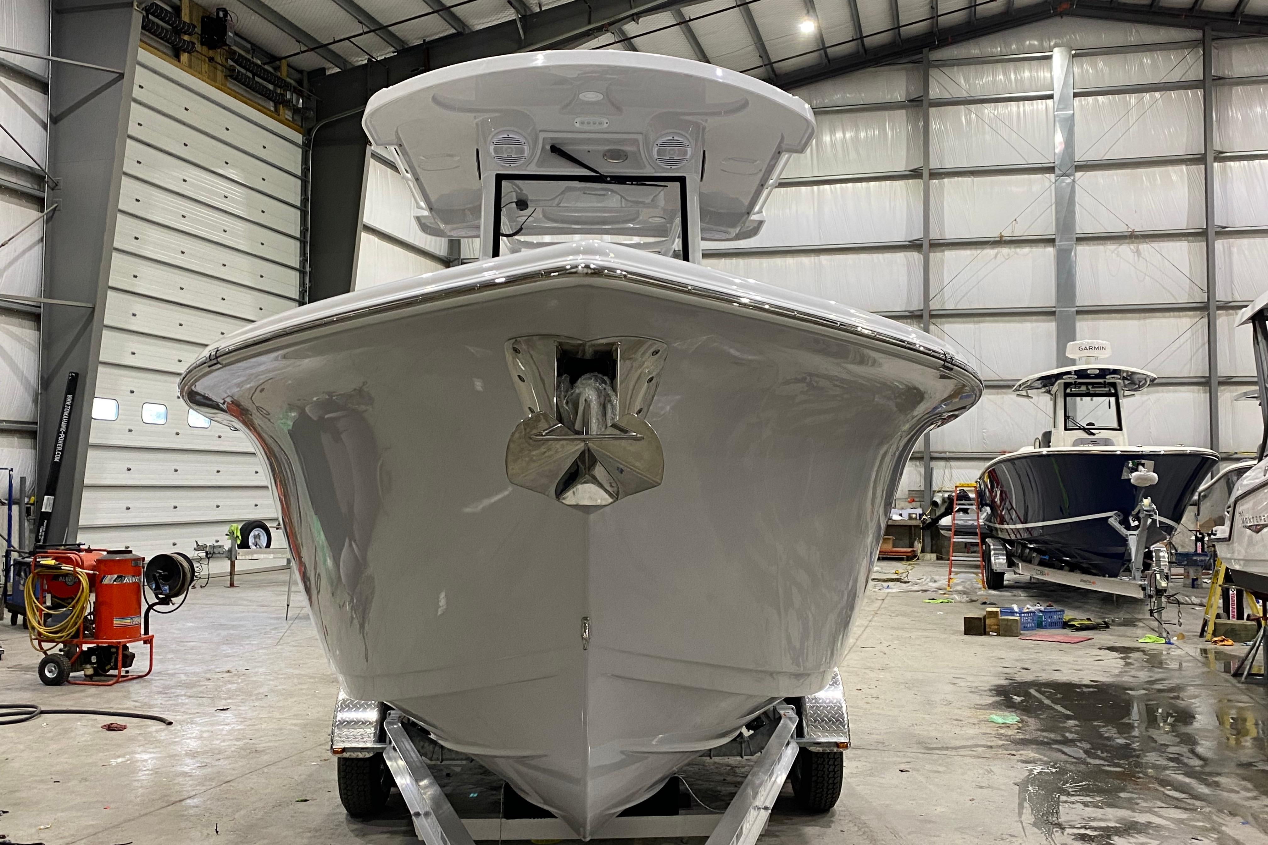2027 Sea Pro 245FLXR Sandbar boat in a spacious indoor facility.