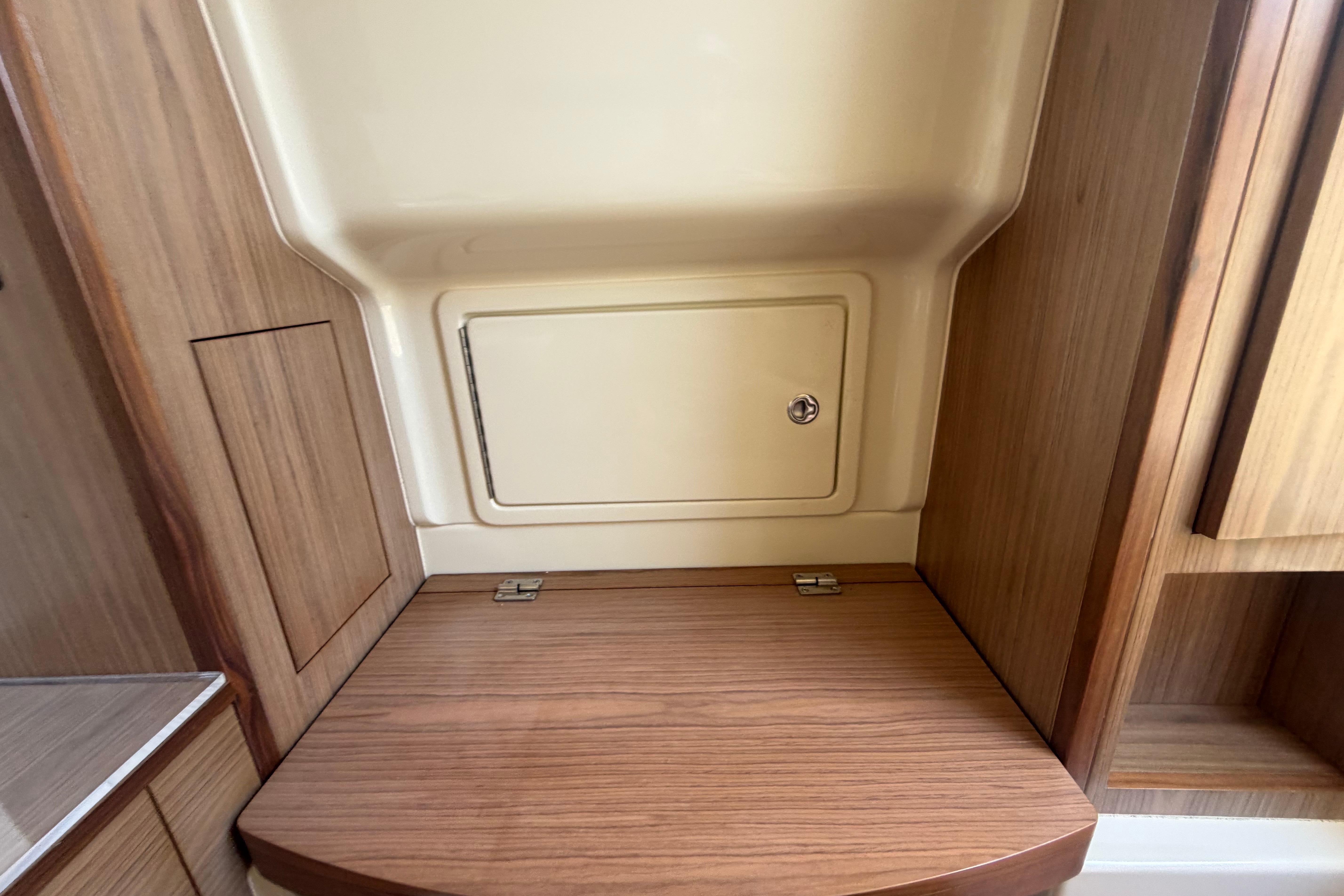 Interior storage compartment on a 2017 Chris-Craft Catalina 34 boat, featuring wood finish.