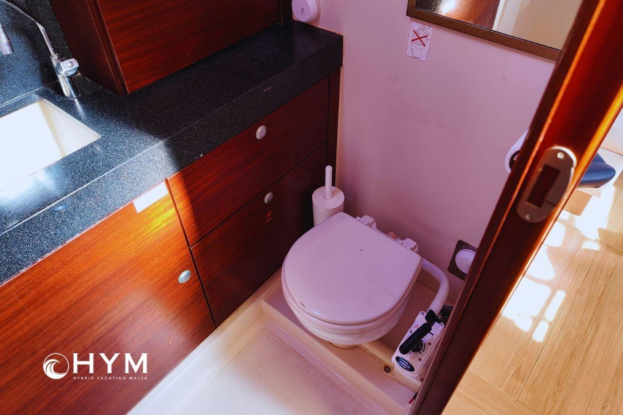 Luxurious 2008 Hanse 470e yacht bathroom with wooden cabinetry and modern fixtures.