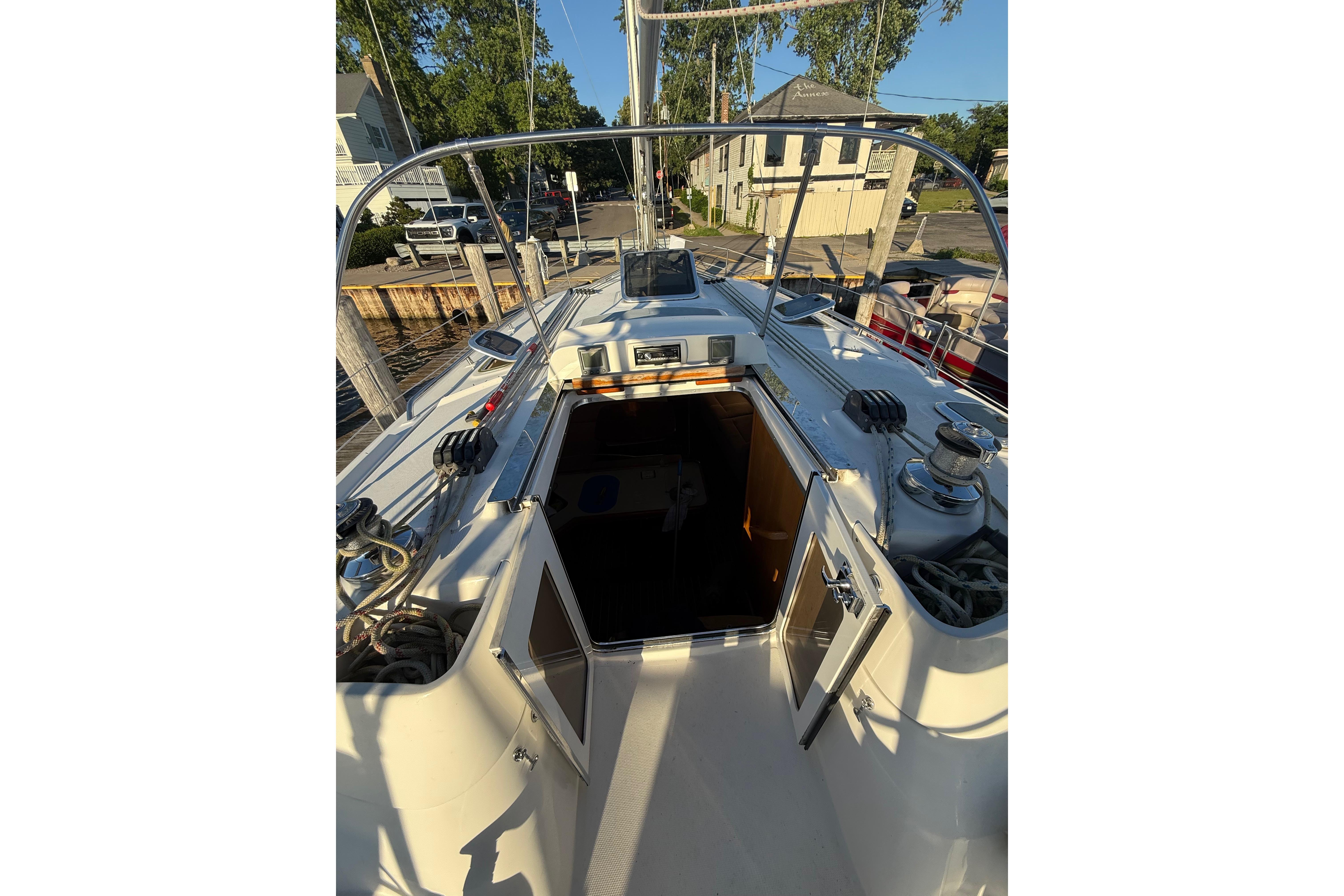 2007 Hunter 41 Deck Salon sailboat cockpit with open cabin doors, docked in a marina.