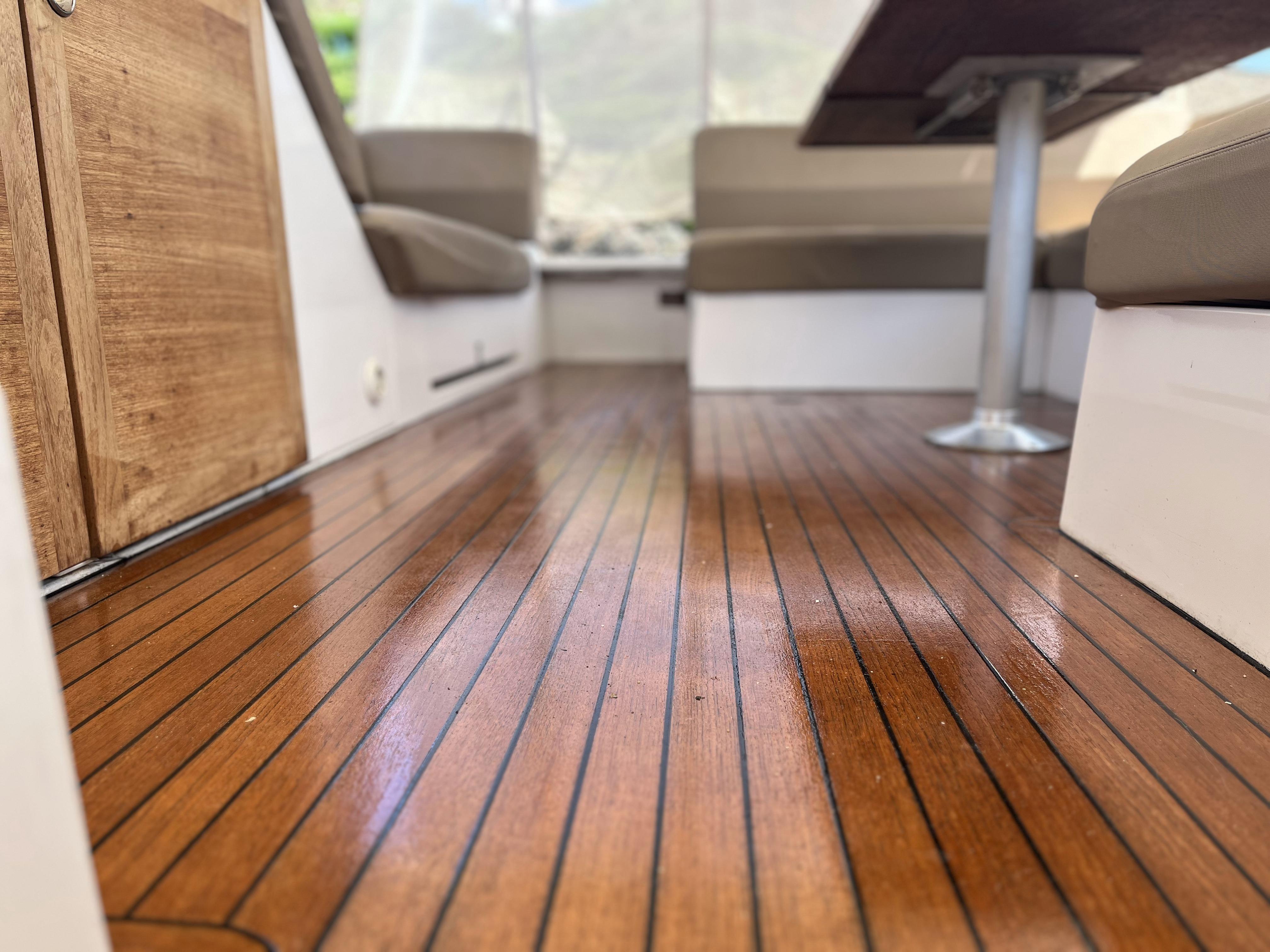 Interior of 2012 Sealine SC 47 yacht with polished wooden flooring and seating area.