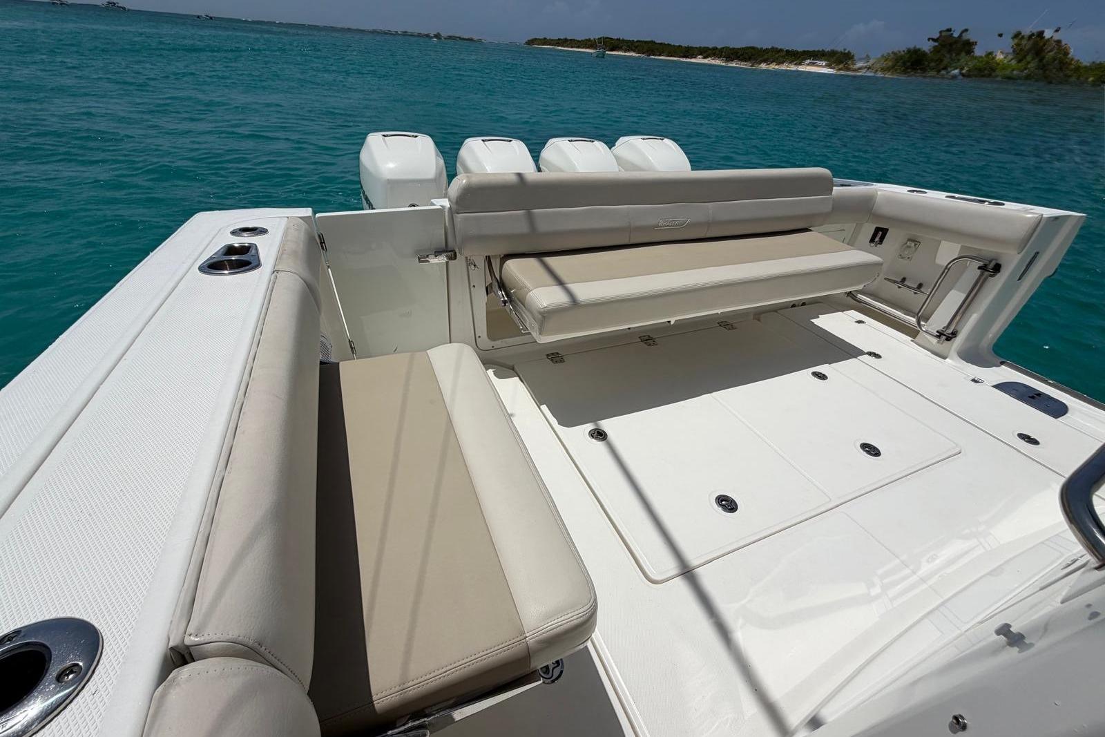 2019 Boston Whaler 420 Outrage boat deck with seating, set against a clear blue ocean backdrop.