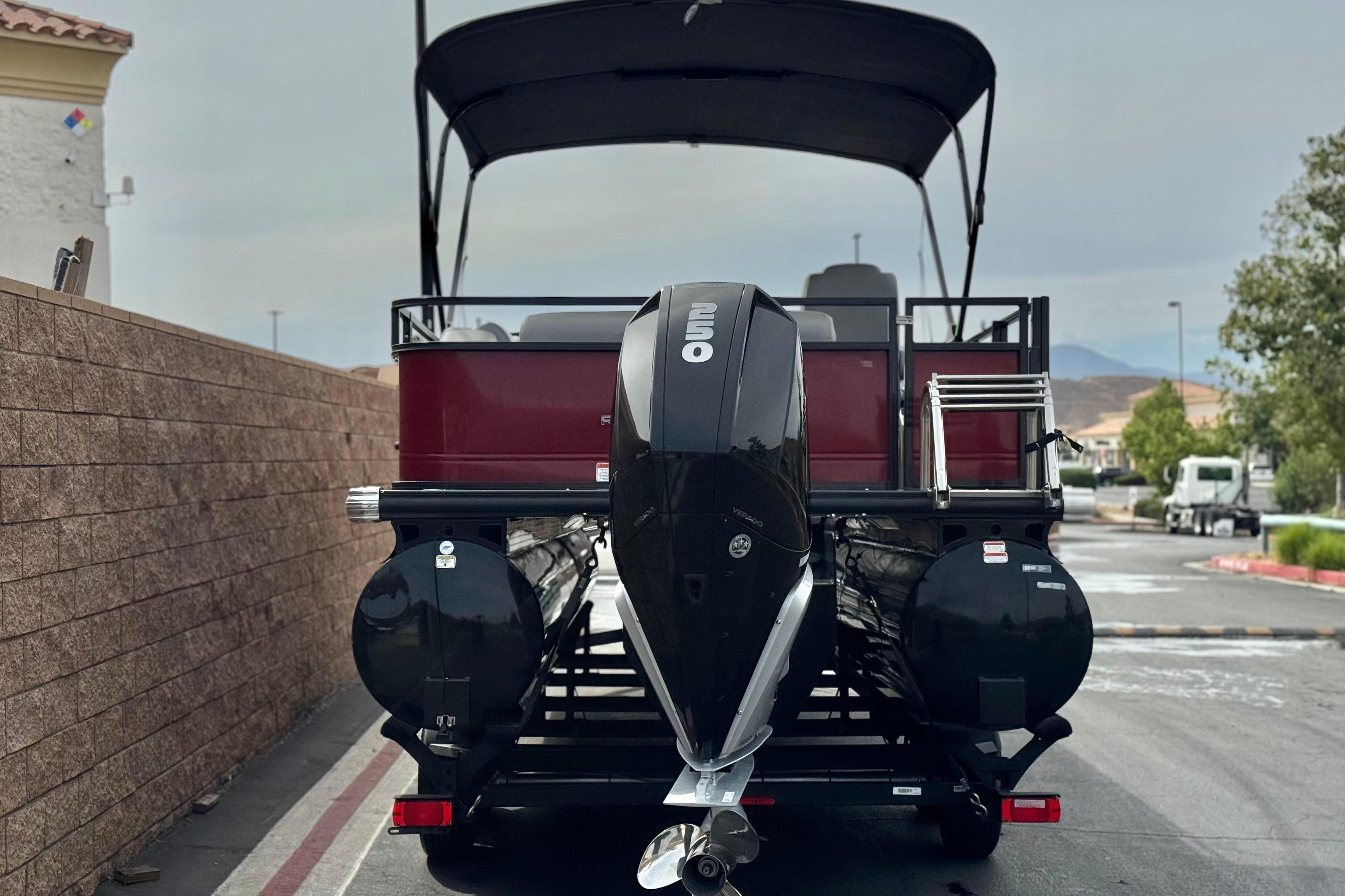 2022 Regency 250 DL3 pontoon boat with outboard motor, parked outdoors.