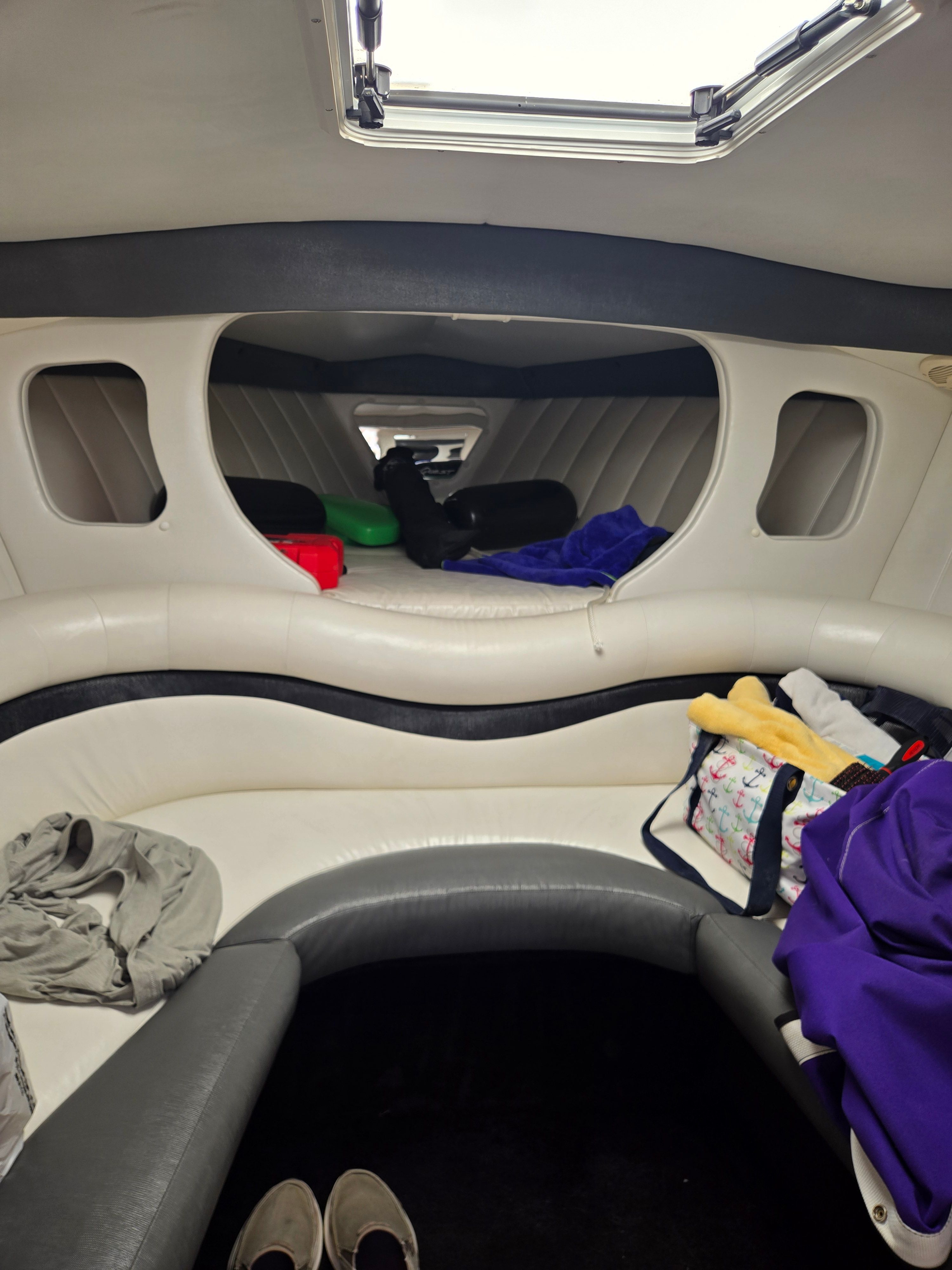 Interior of a Powerquest 340 Vyper with white upholstery and luggage.