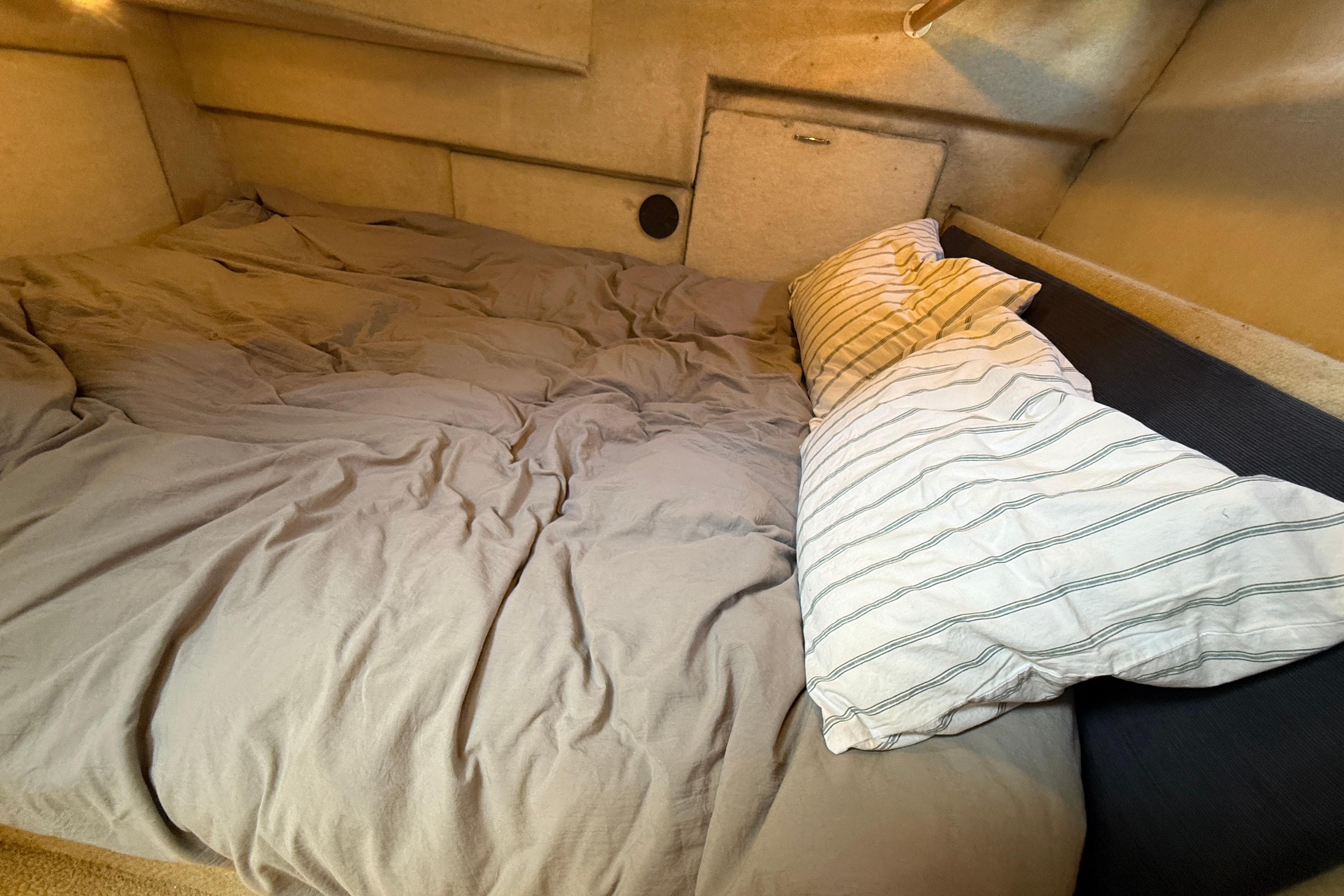 Cozy sleeping area in 1997 Bayliner 3988 Command Bridge Motoryacht with pillows and bedding.