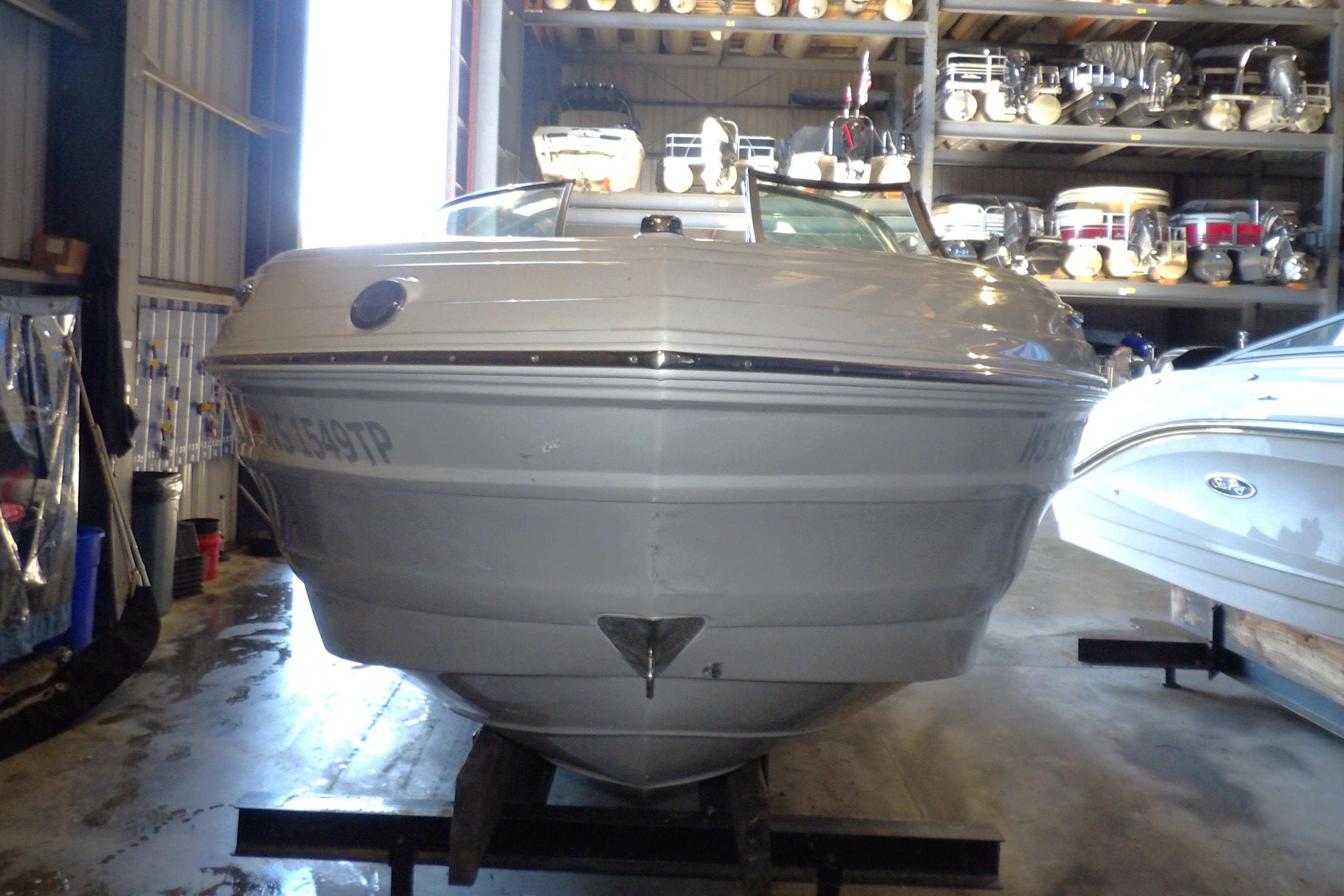 2023 Crownline 250 XSS boat in storage, front view, showcasing sleek design.