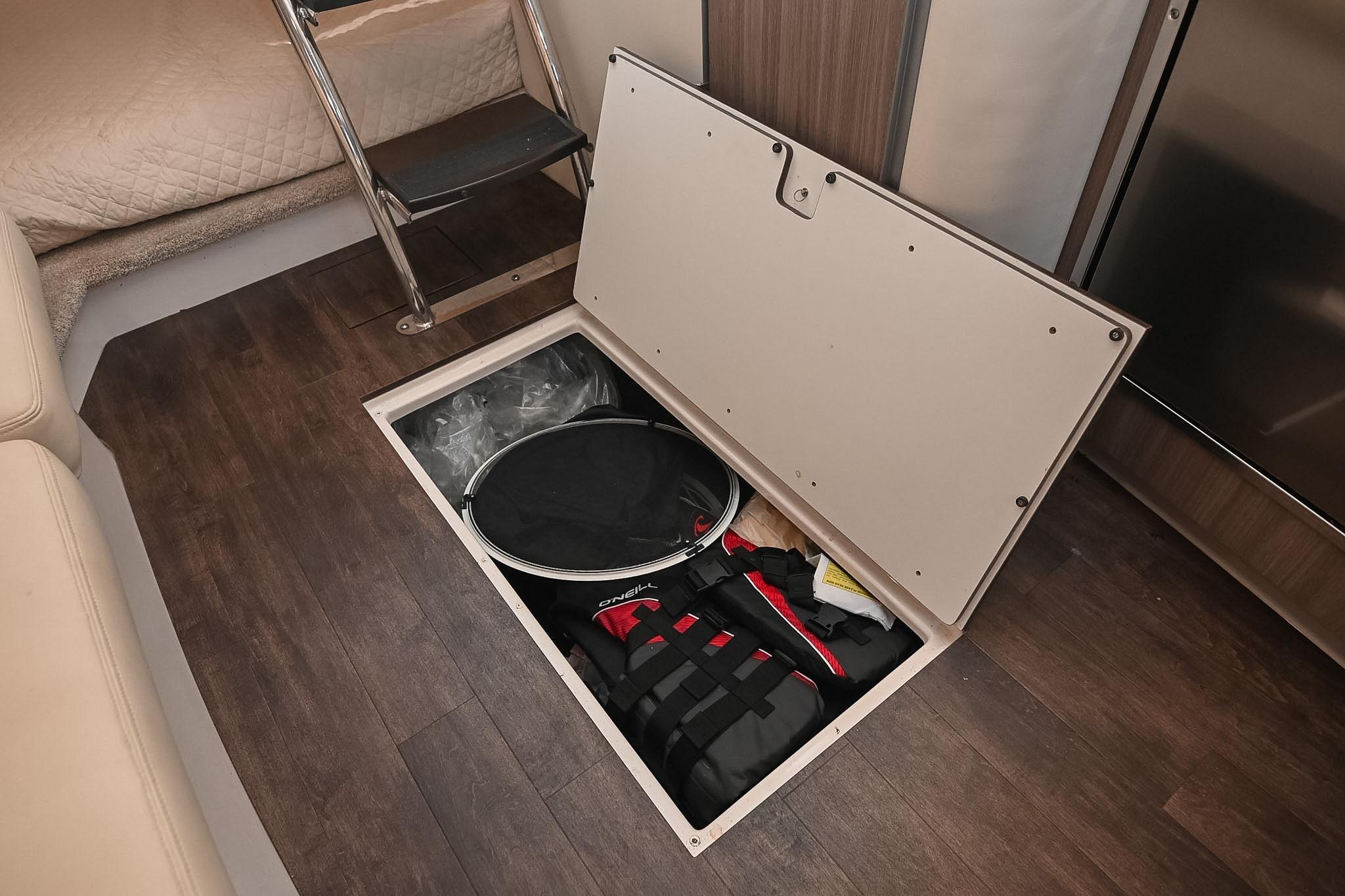 Underfloor storage compartment in 2021 Regal 33 Express boat interior, featuring various equipment.