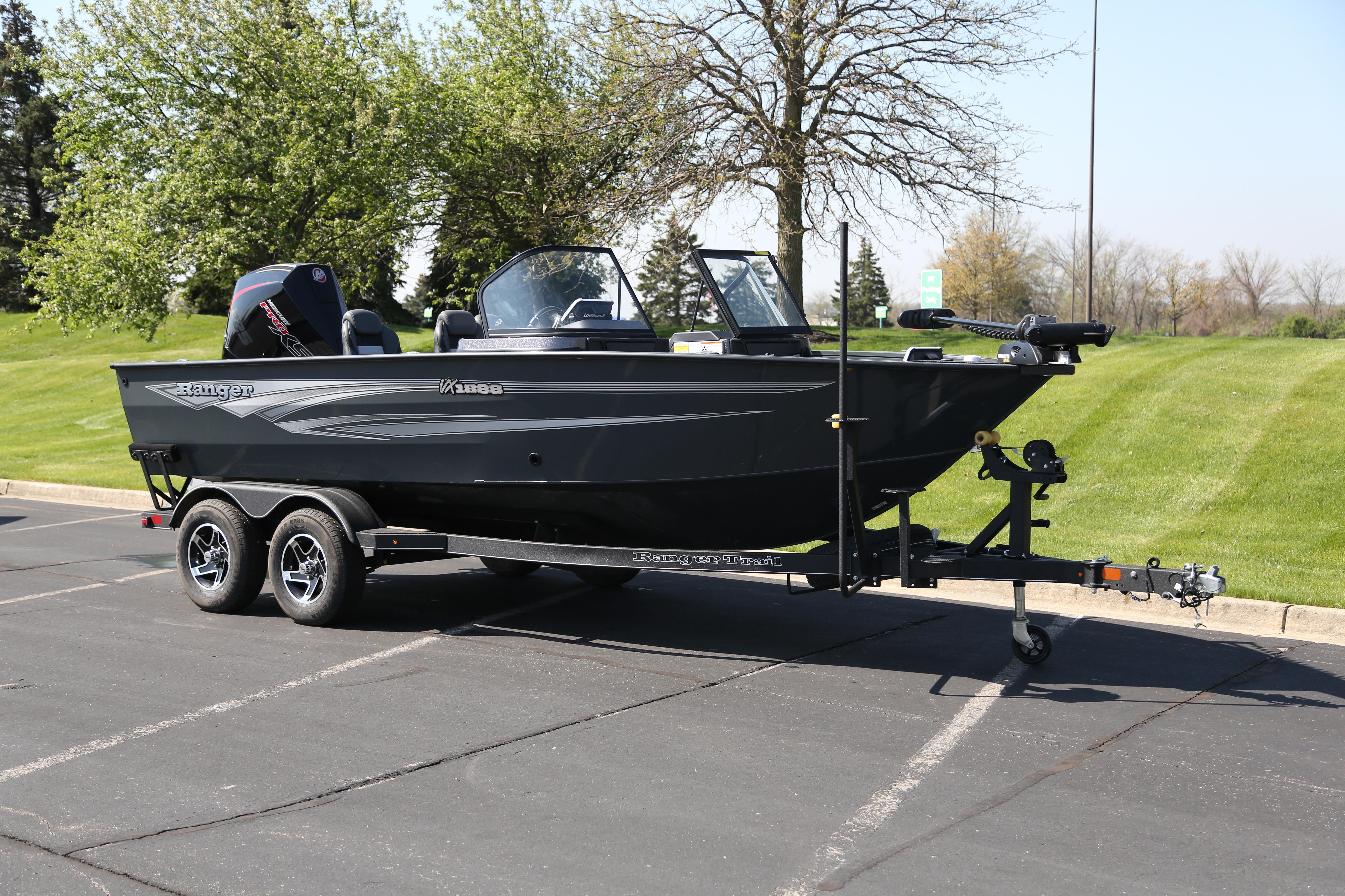 2026 Ranger VX1888 WT boat on trailer in parking lot, surrounded by greenery.