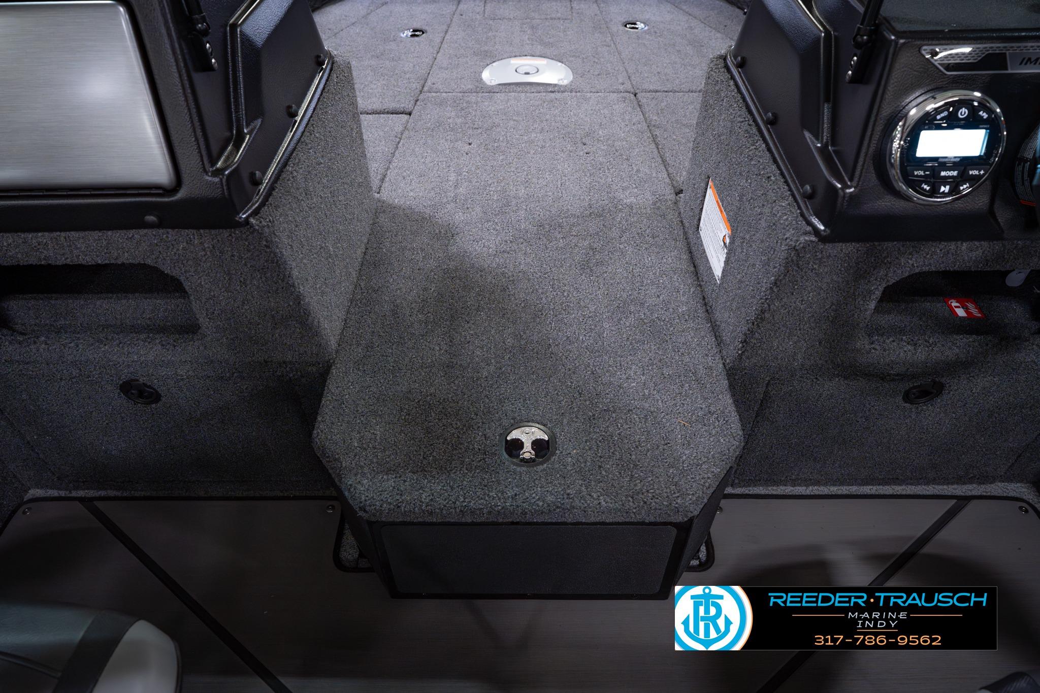 2026 Lund 1875 Impact XS SS boat interior with carpeted flooring and control panel.