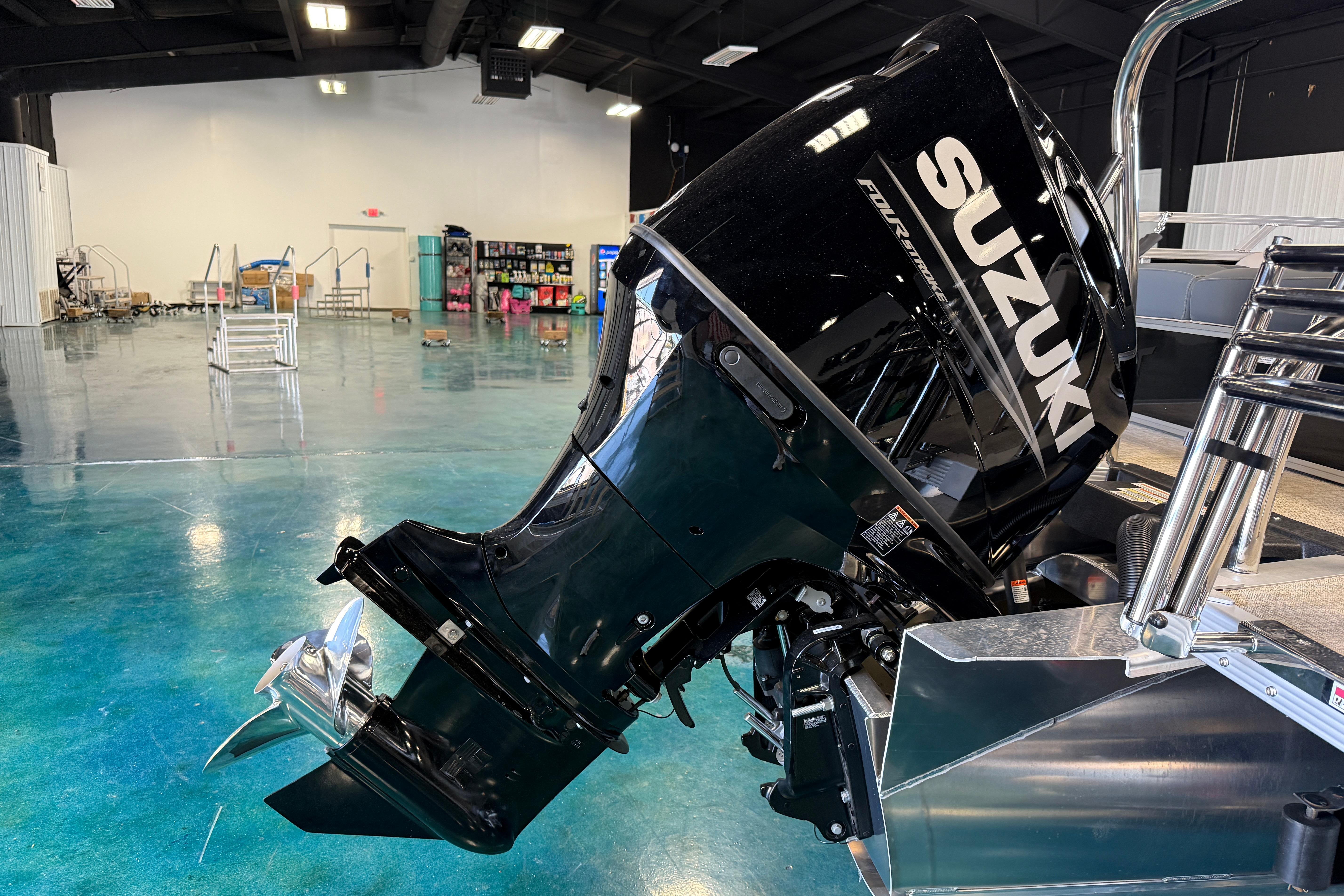 2026 Tahoe Pontoon LTZ Entertainer with Suzuki outboard motor in showroom.
