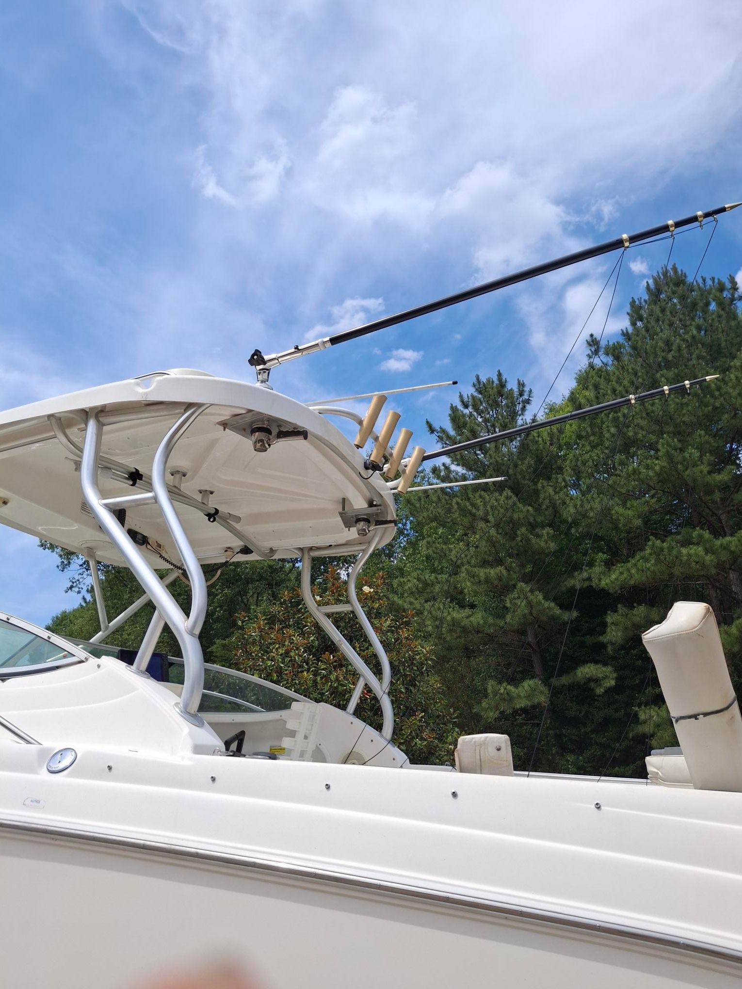 A 2008 Wellcraft 252 Coastal boat with fishing rod holders and a sturdy roof.