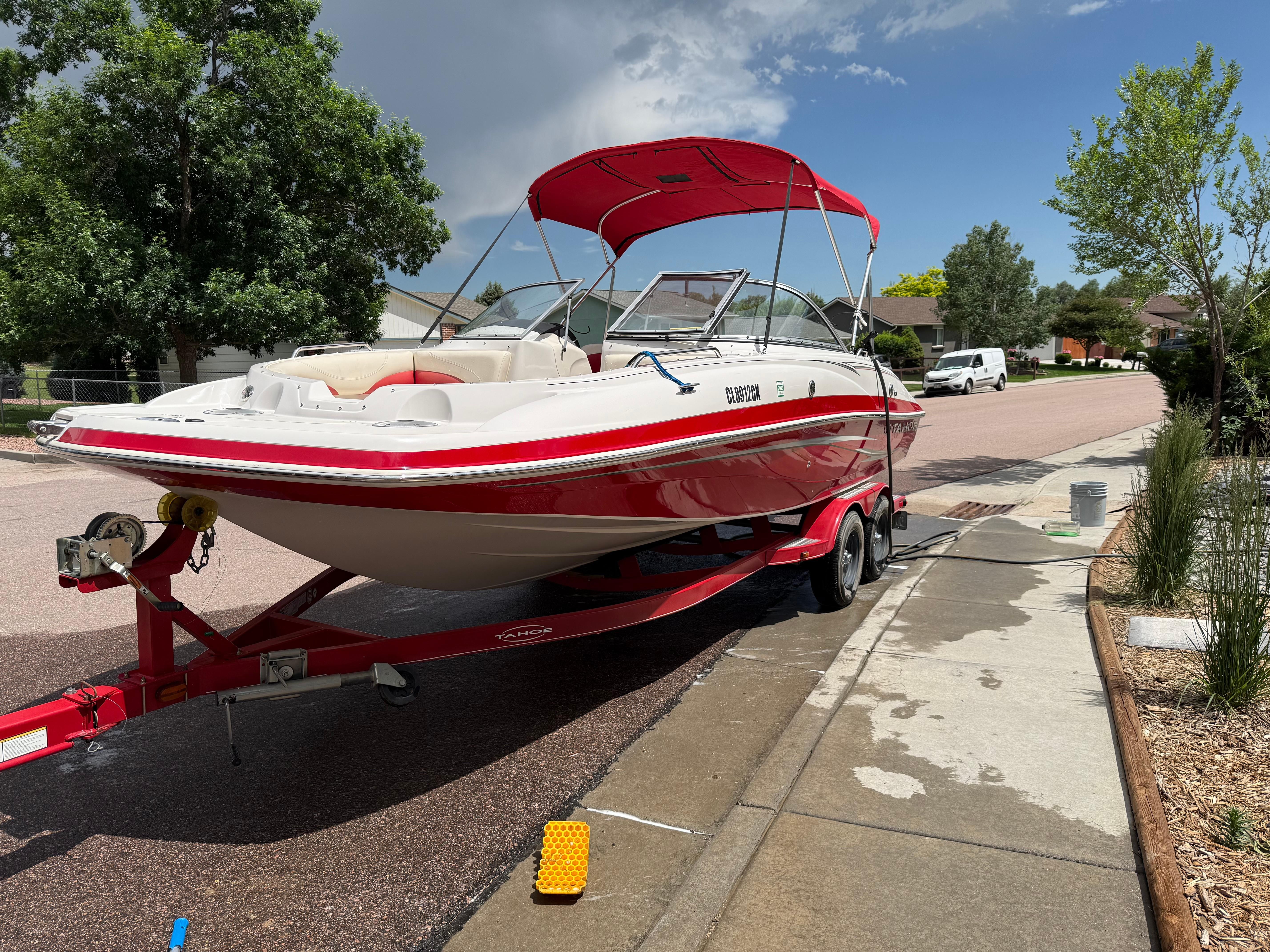 2011 Tahoe 216 WT boat on trailer in residential area.
