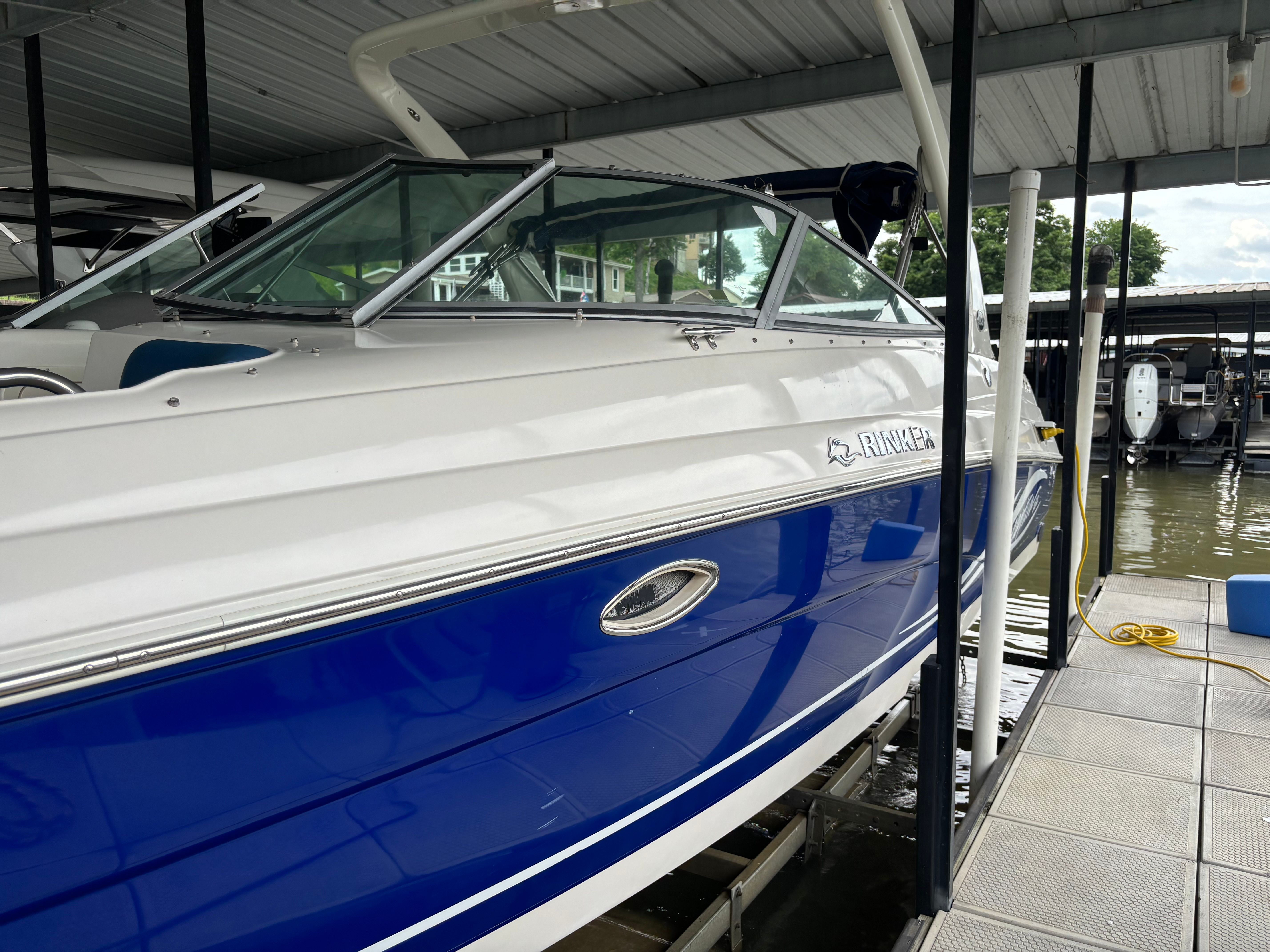A 2006 Rinker 282 Captiva Bowrider is docked in a covered boat slip.