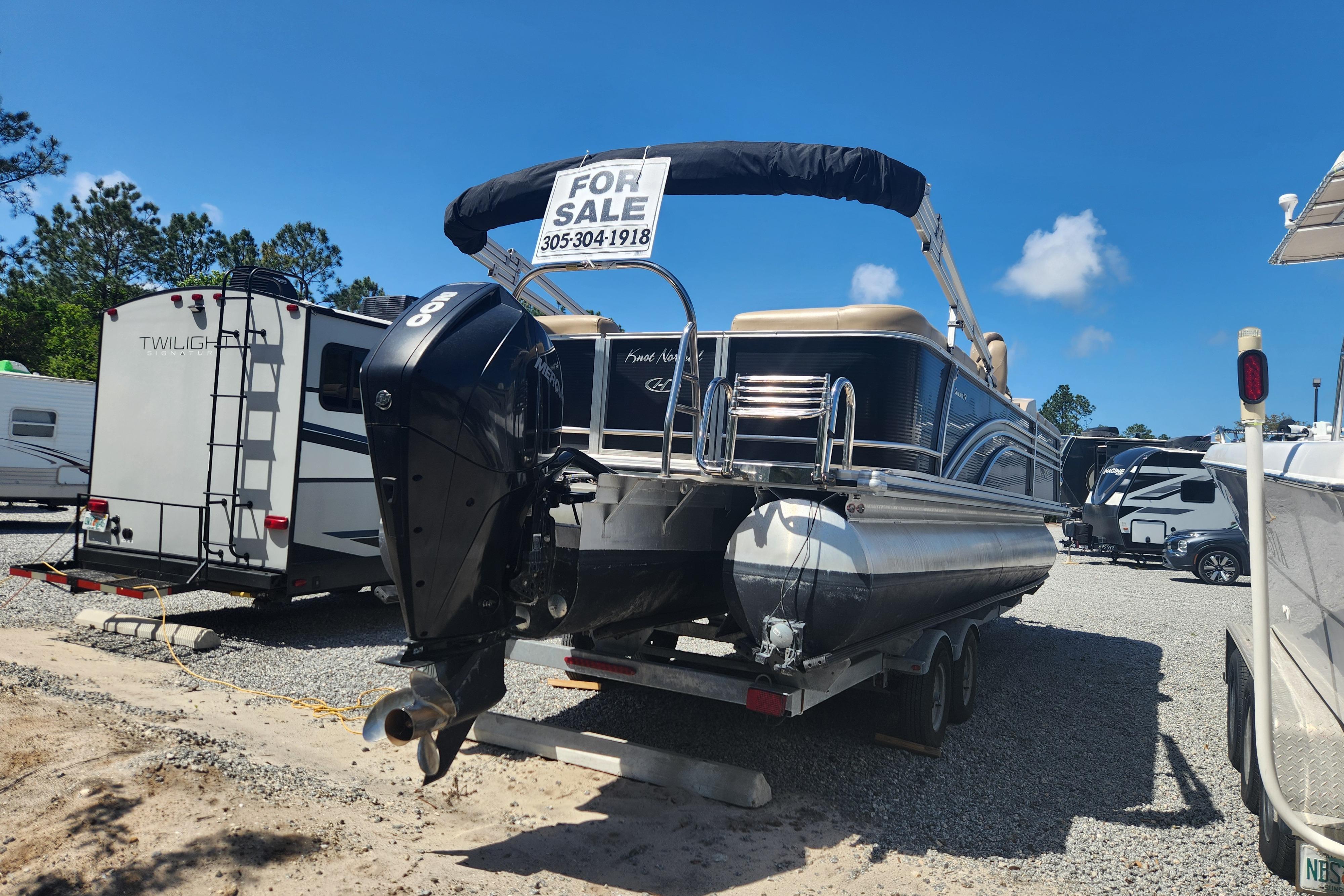 2019 Harris Sunliner 250 pontoon boat for sale in a parking lot.