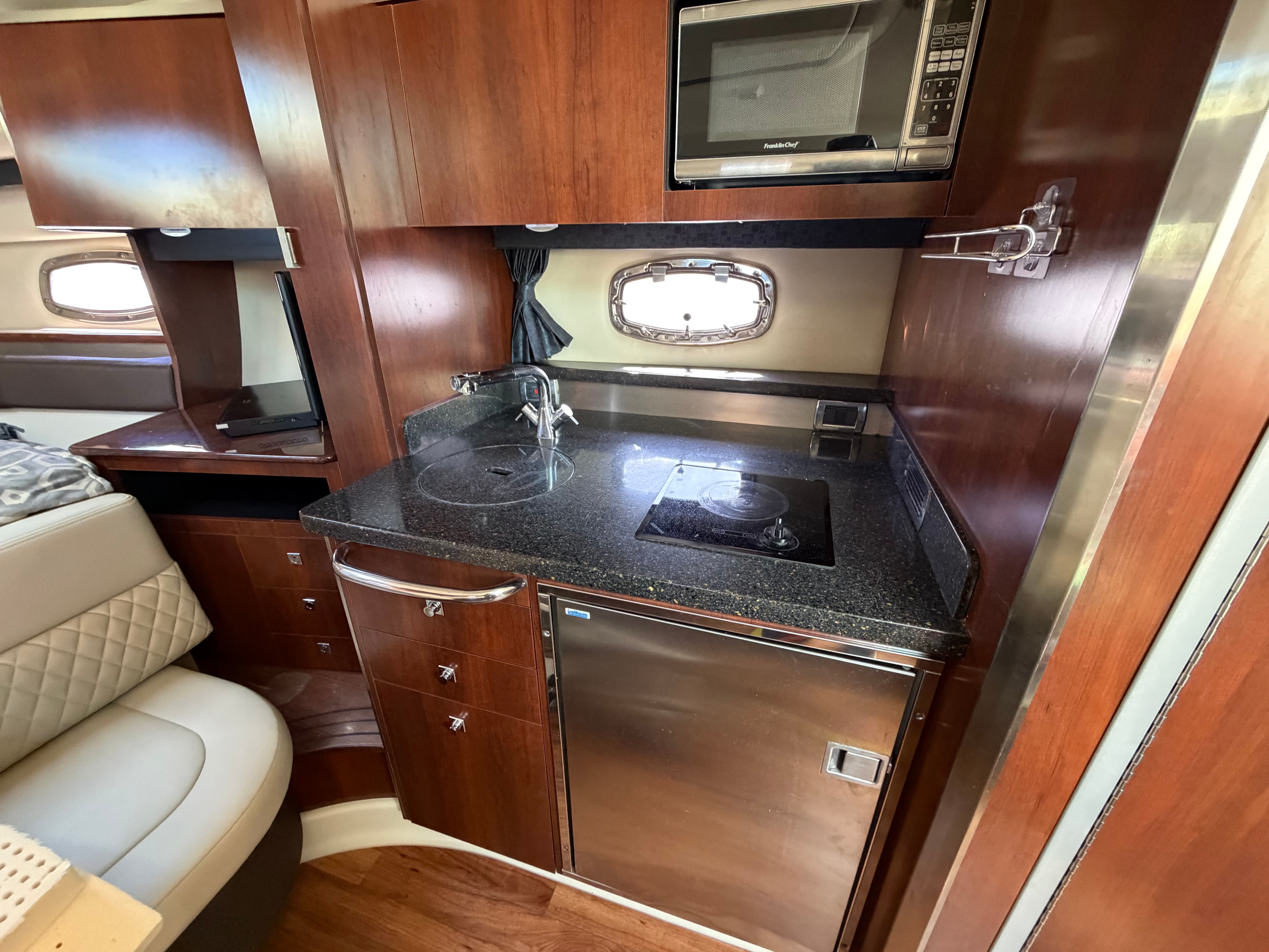 Interior of 2014 Chaparral 330 Signature with kitchenette and microwave.