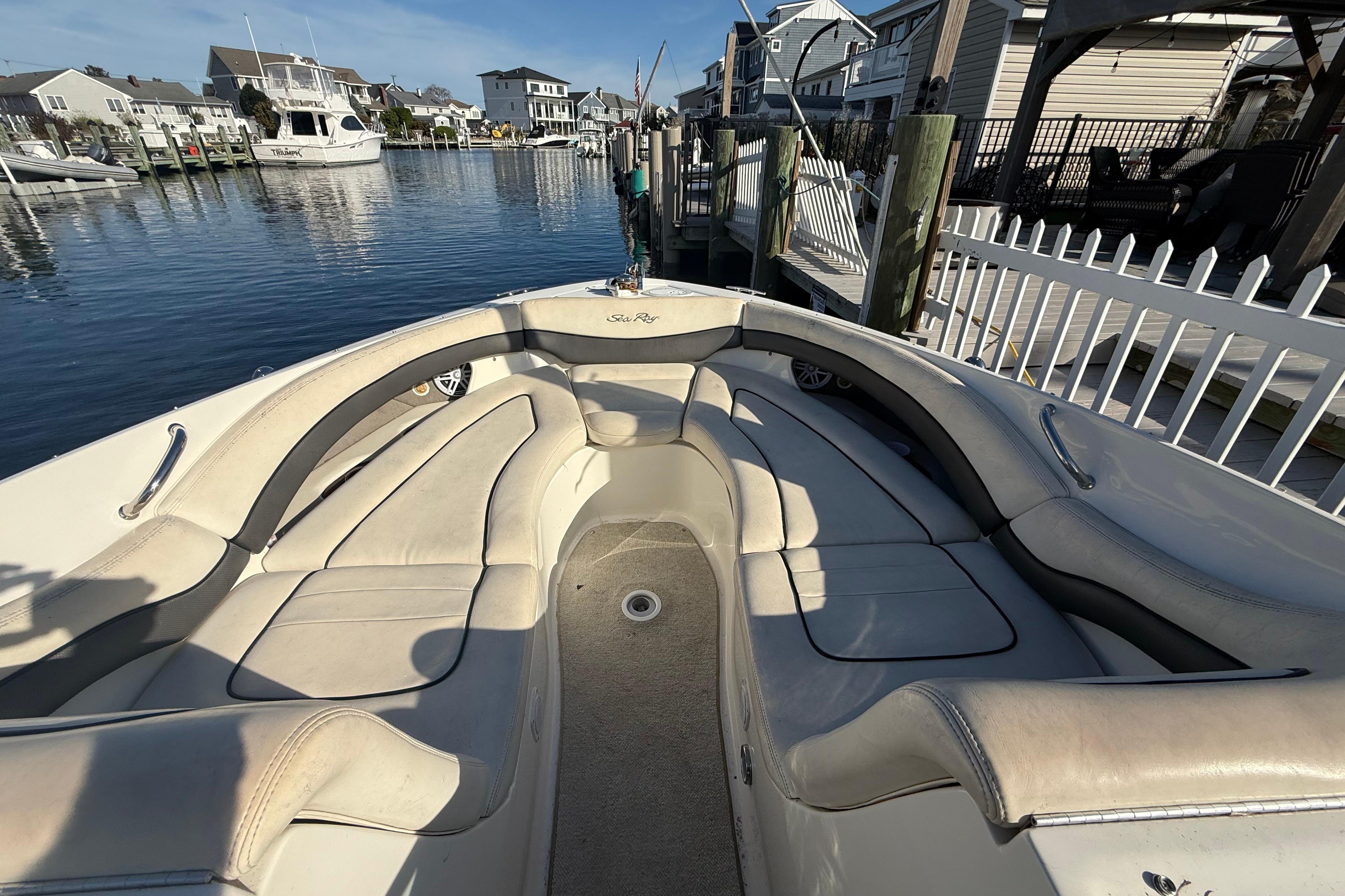 2005 Sea Ray 290 SLX boat interior with beige seating, docked in a residential marina.