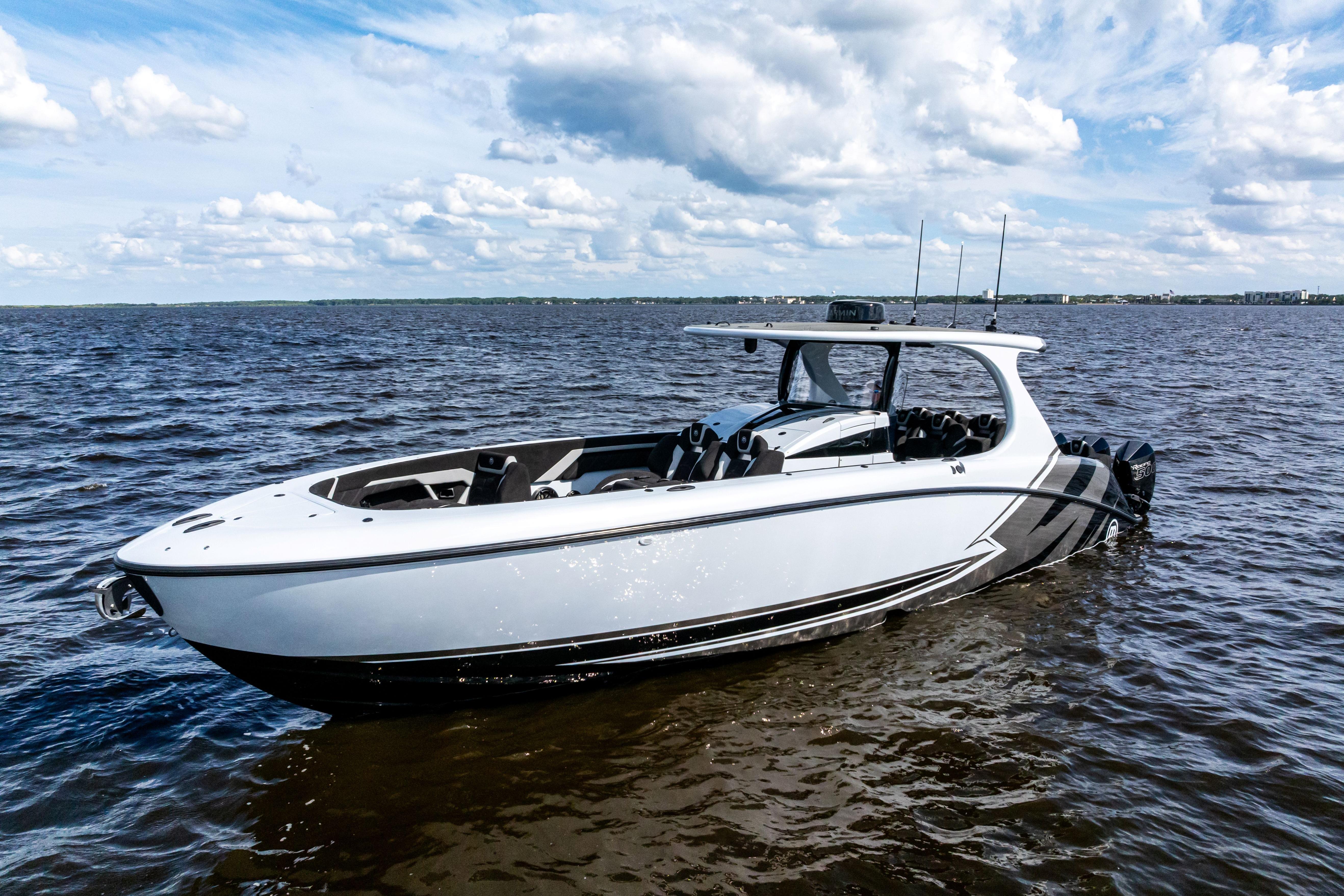 2027 Mystic Powerboats M4200 on open water under a partly cloudy sky.