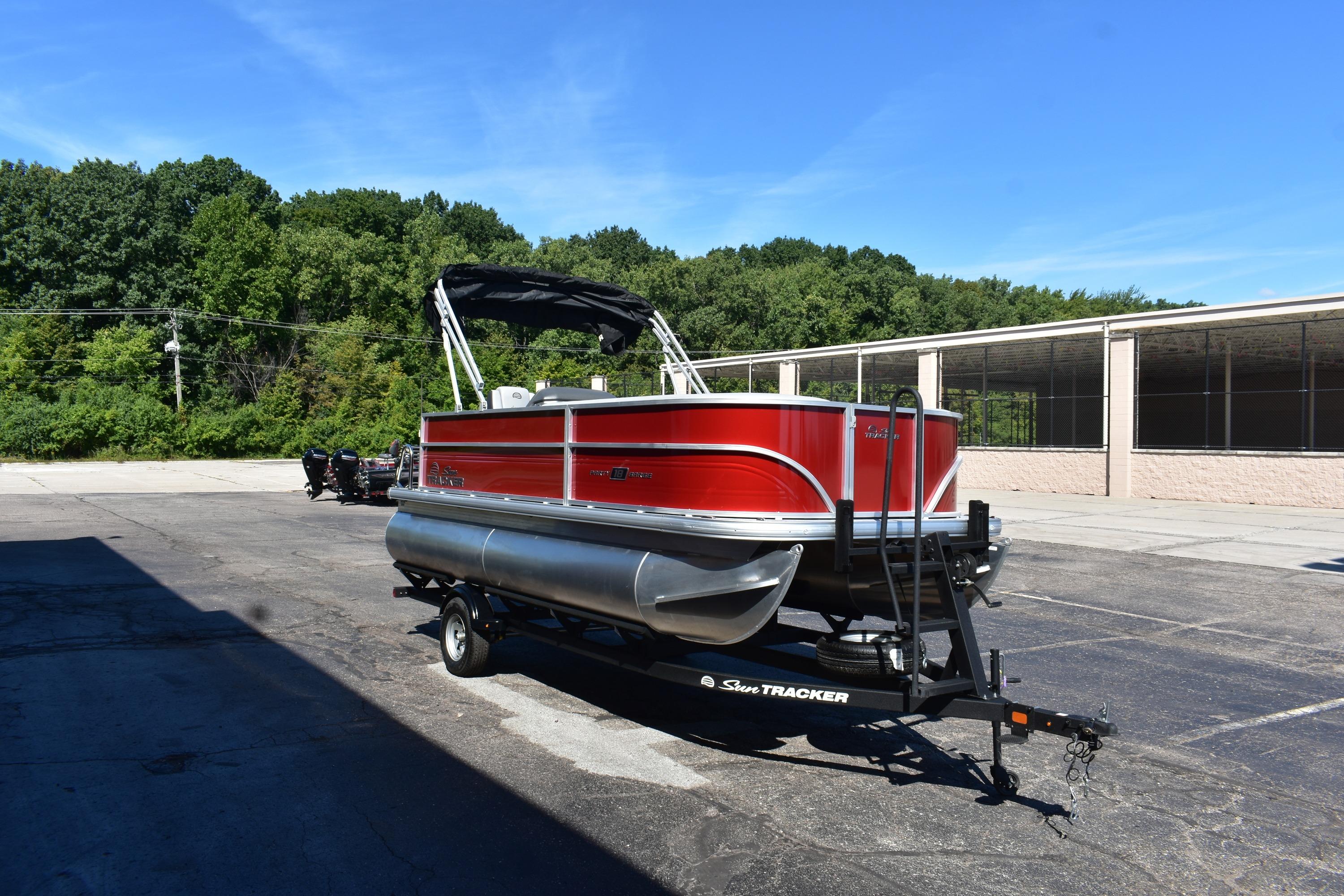 2026 Sun Tracker Party Barge 18 DLX pontoon boat on trailer, parked outdoors.