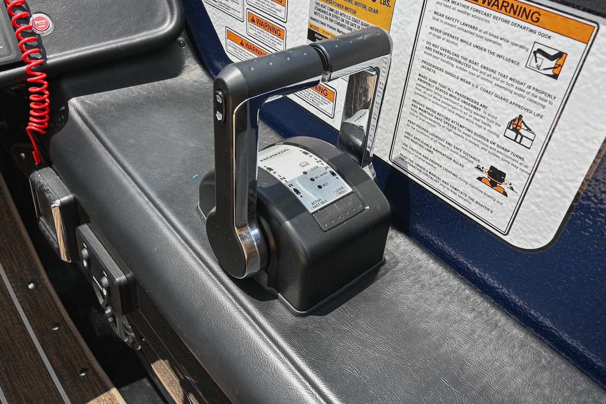 Throttle control and warning labels on 2023 Premier 270 Intrigue RF boat dashboard.
