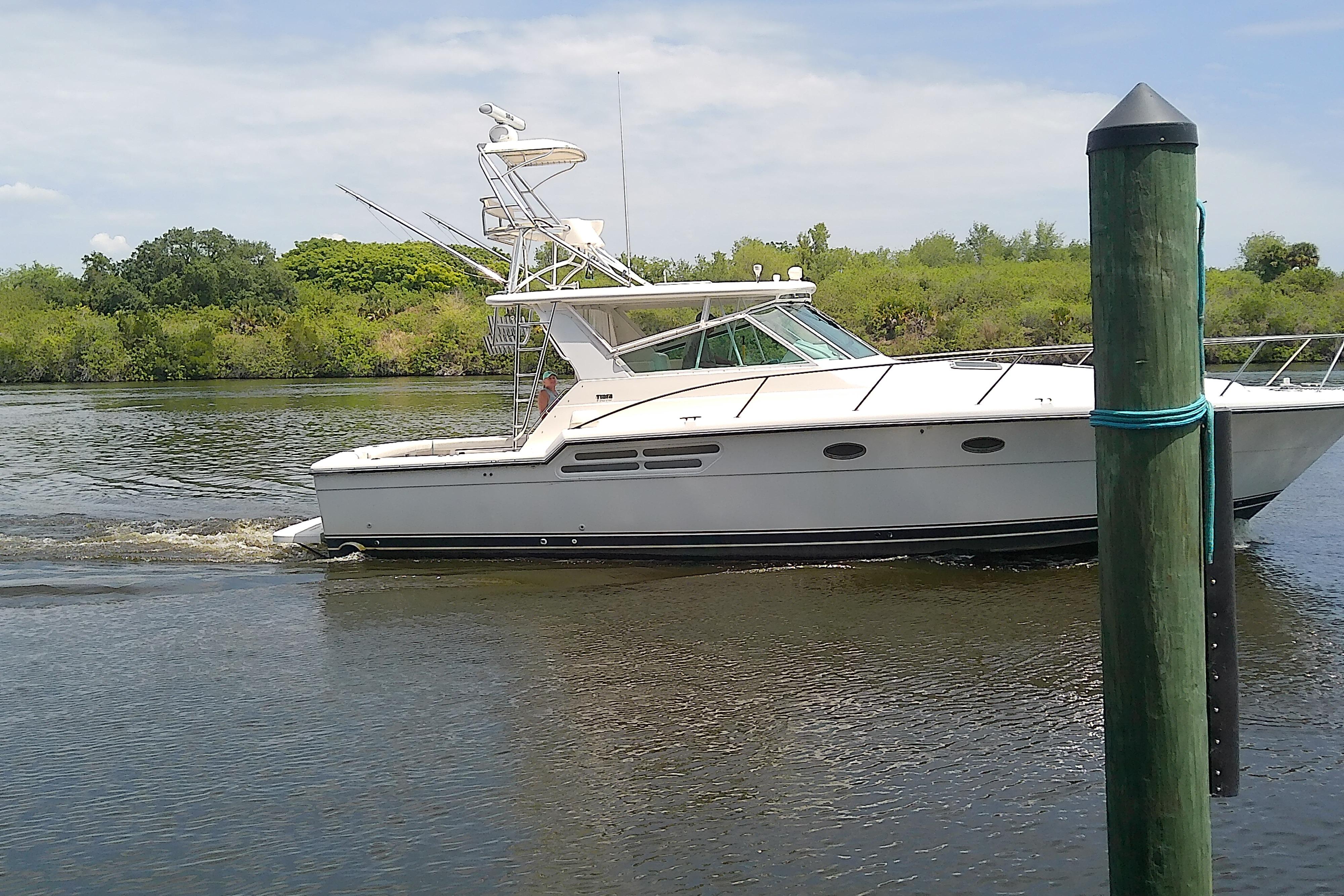 2000 Tiara Yachts 4100 Open cruising on a calm river with lush greenery.