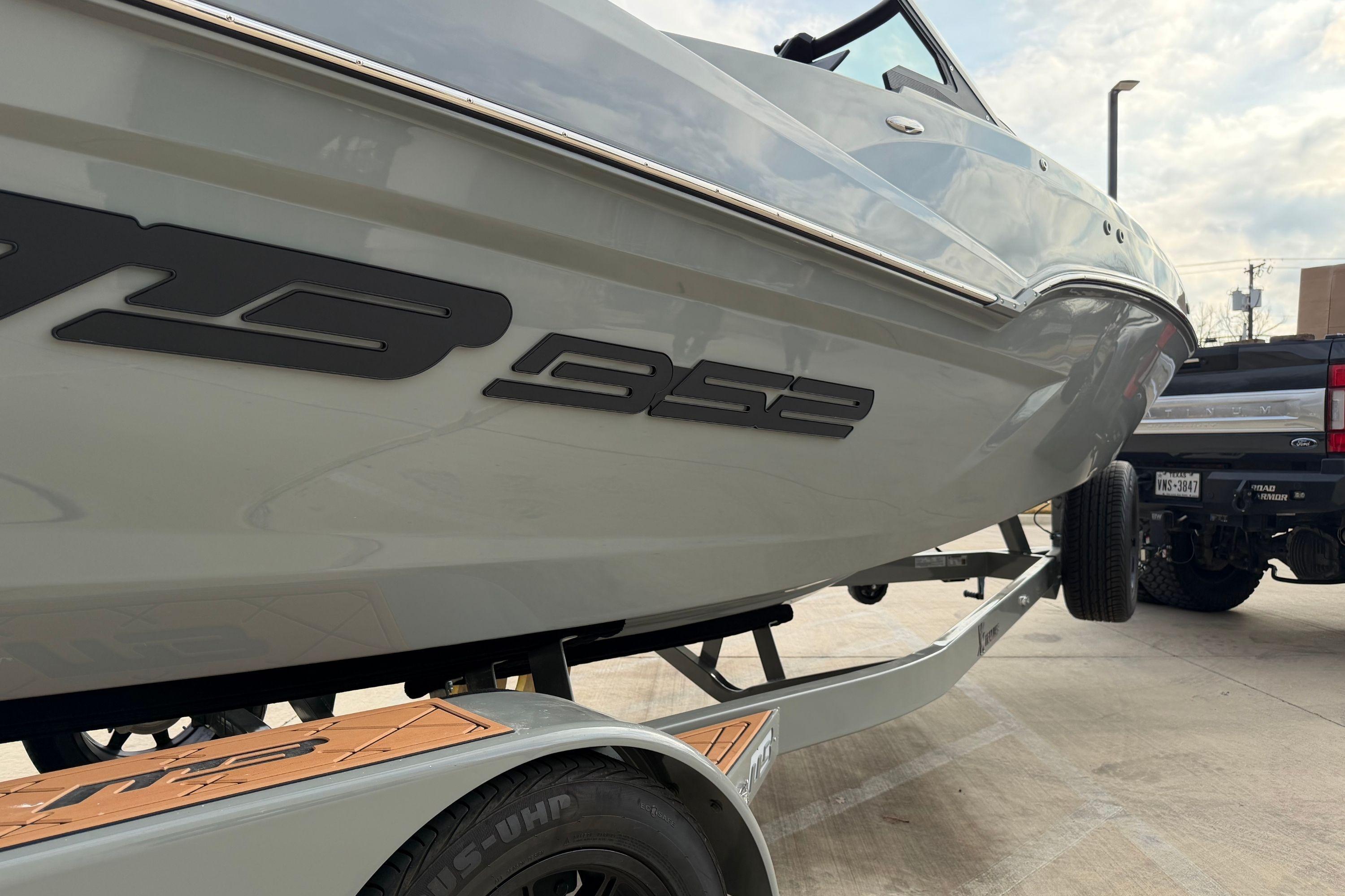 2026 MB B52 21 Alpha boat on trailer, parked beside a truck.