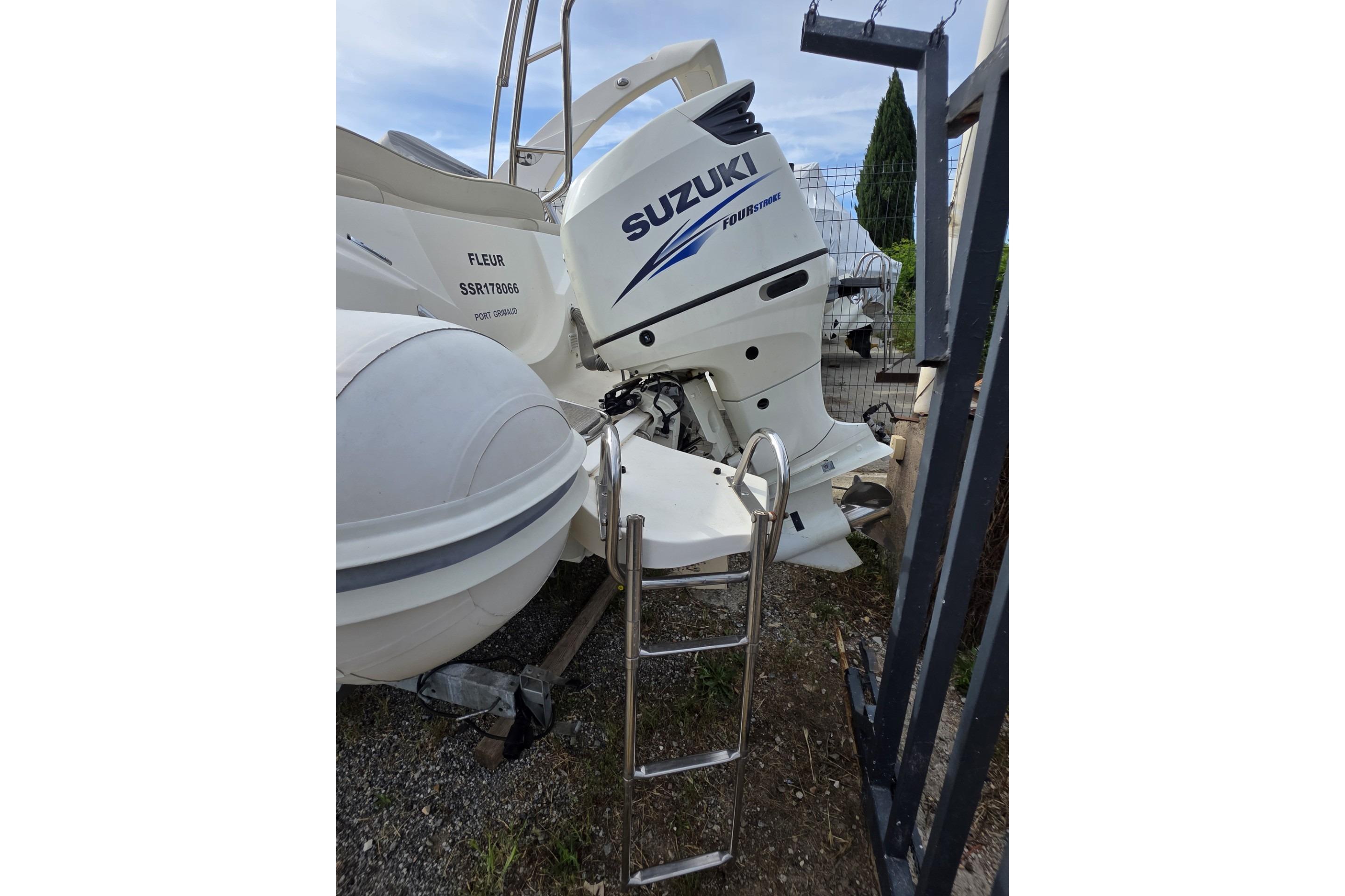Nuova Jolly 650 boat with Suzuki outboard motor, 2015 model, parked with ladder access.