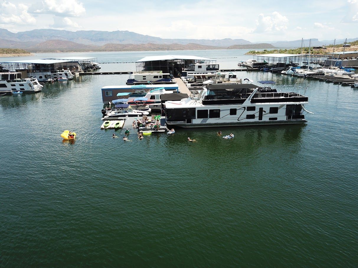 2006 Summersun 16x68 houseboat in marina with swimmers in water.