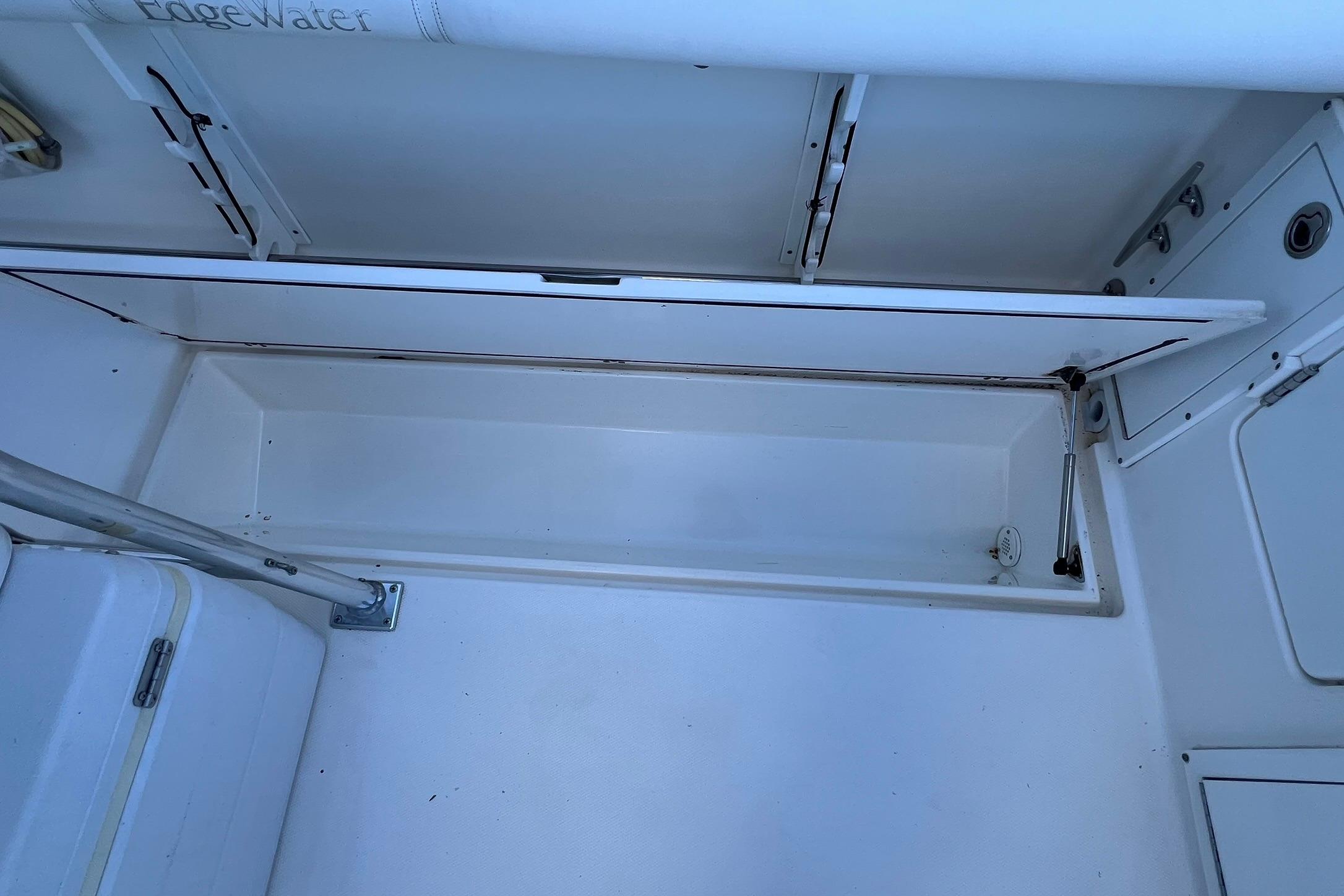 Open storage compartment on a 2006 Edgewater 245CC boat, showcasing interior space.