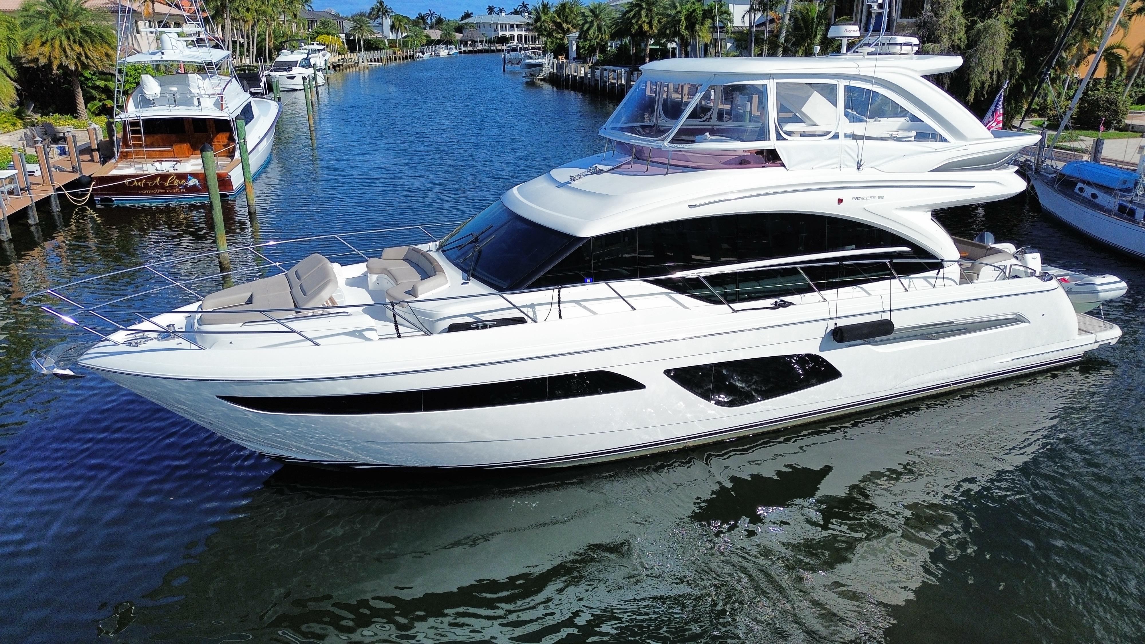 Luxurious 2019 Princess F62 yacht docked in a scenic marina.