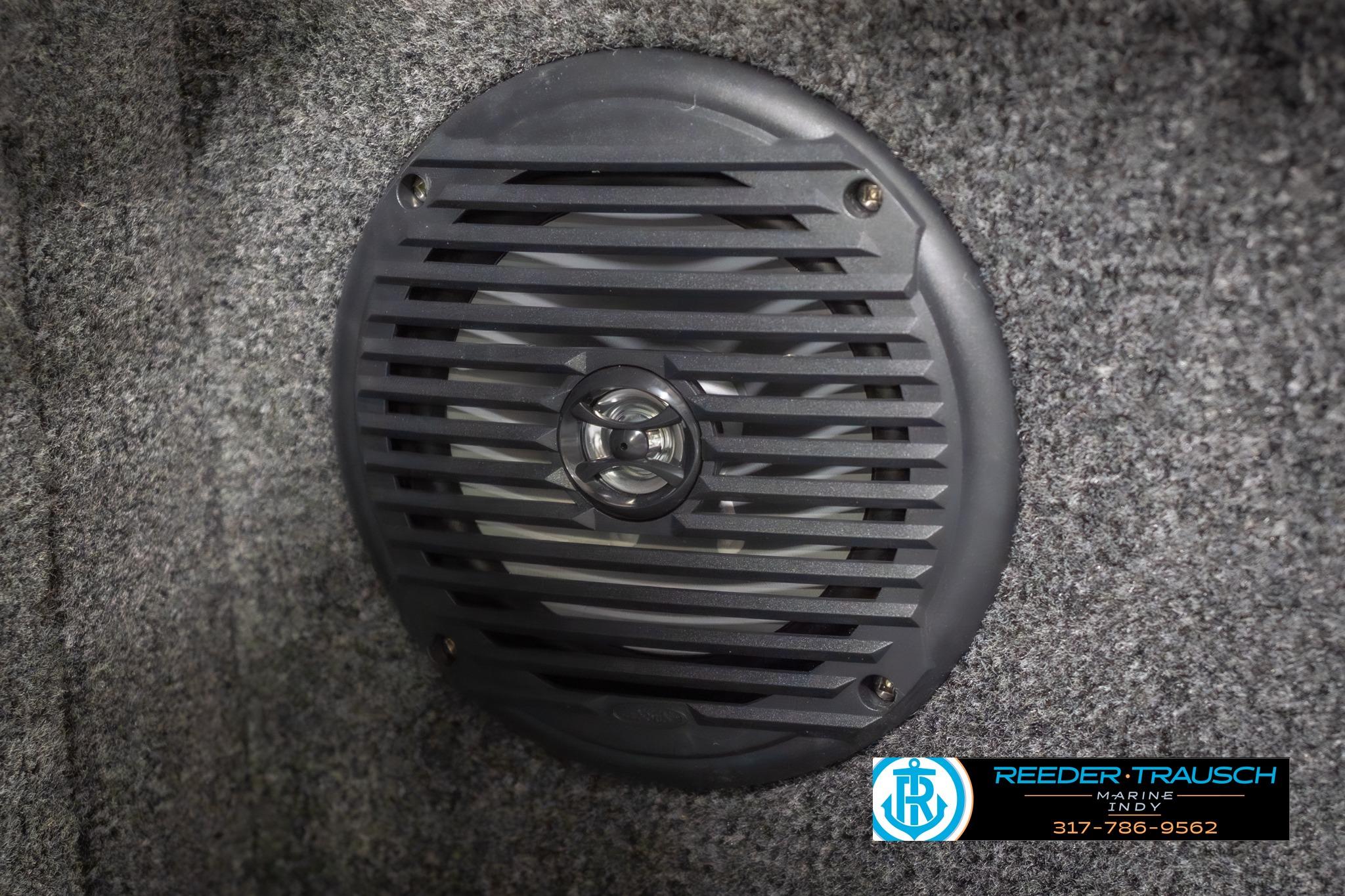 Speaker grill on 2026 Lund 2075 Impact XS boat interior, gray carpeted surface.