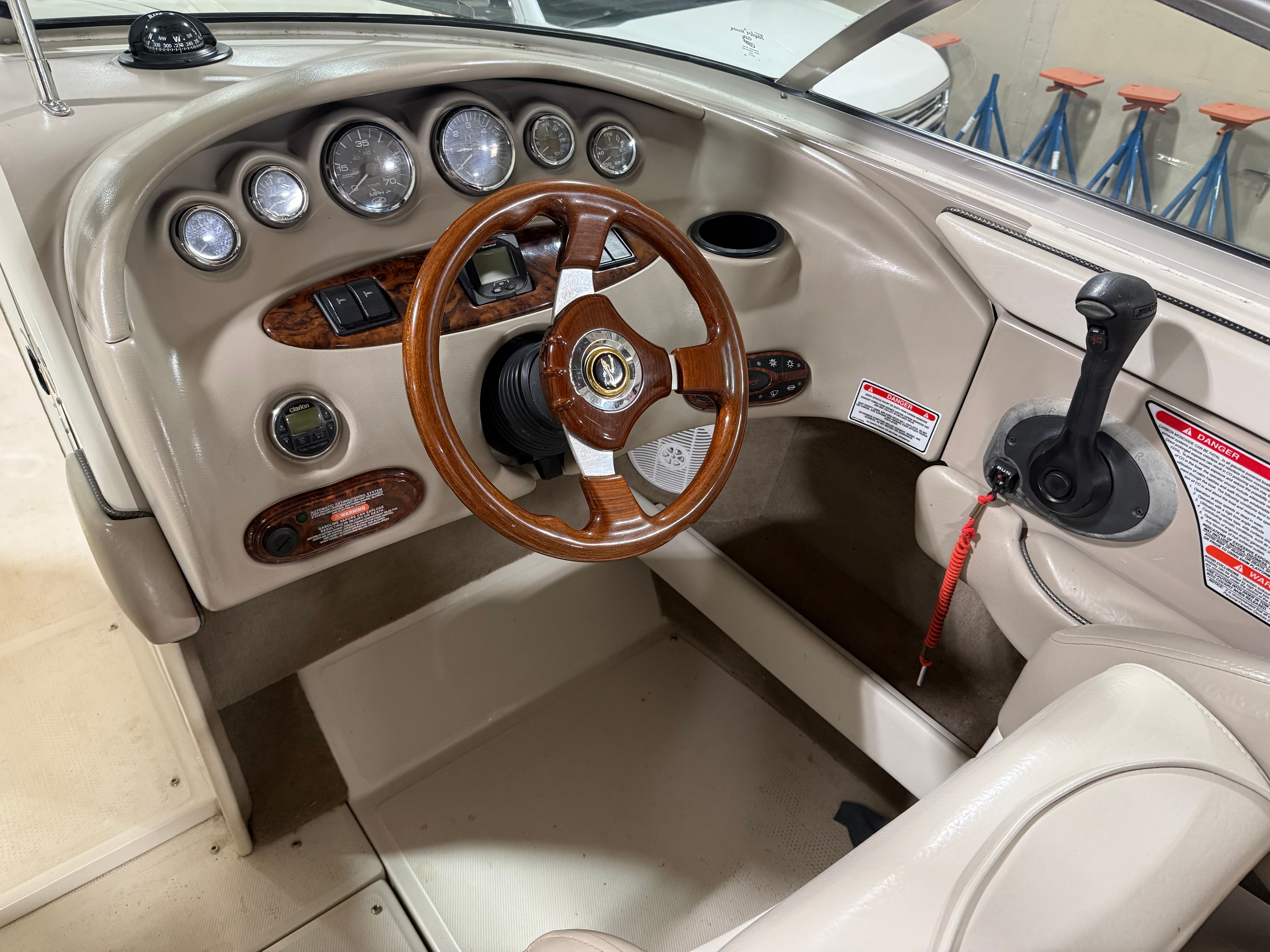 Interior of a 2003 Sea Ray 240 SIGNATURE boat with wooden steering wheel.