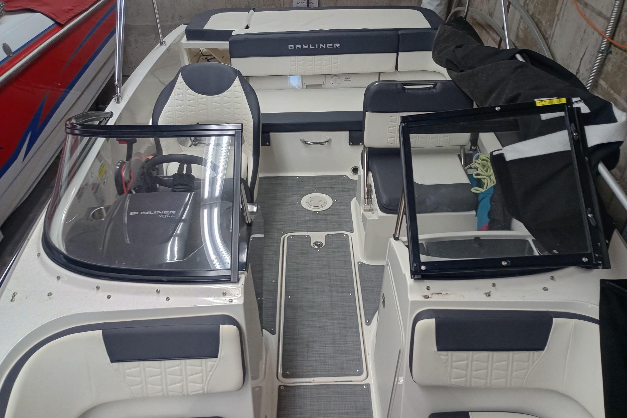 2022 Bayliner VR5 Bowrider I/O interior with seating and steering wheel in a garage.