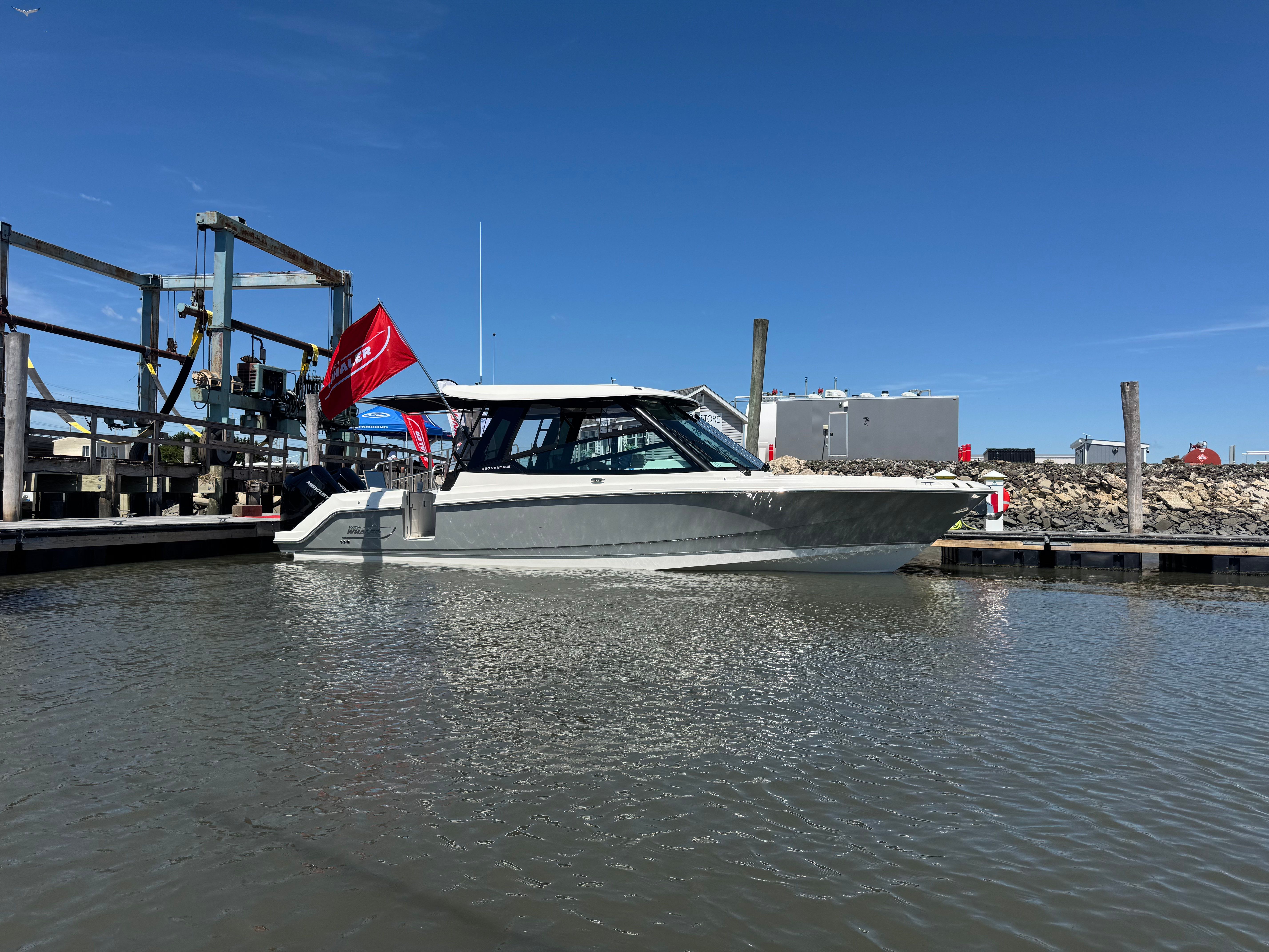 2025 Boston Whaler 330 Vantage in the water at a dock.