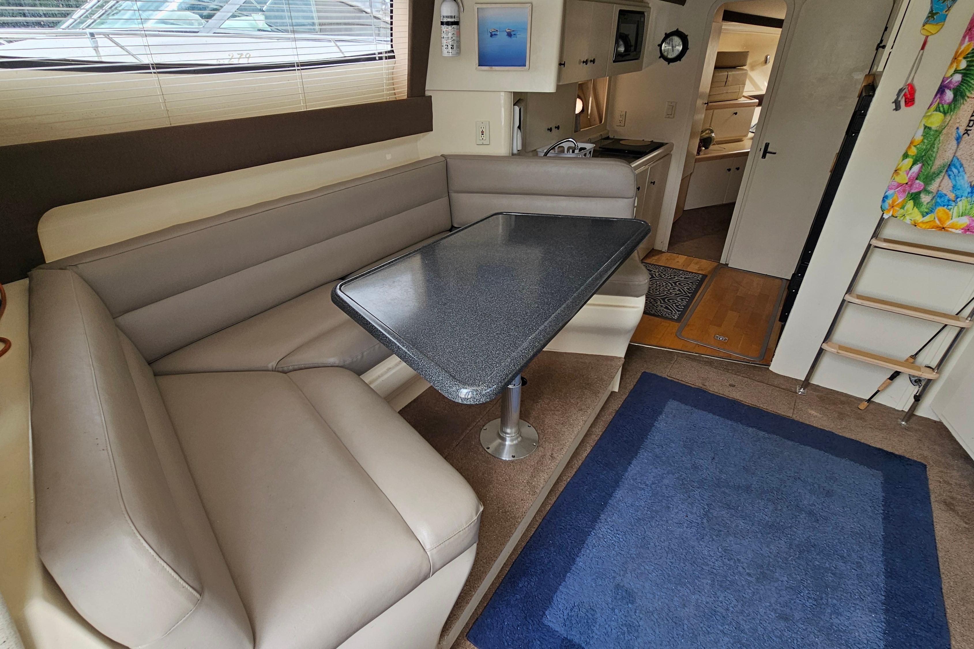Interior of a 1999 Carver 350 Mariner yacht with a cozy dining area.