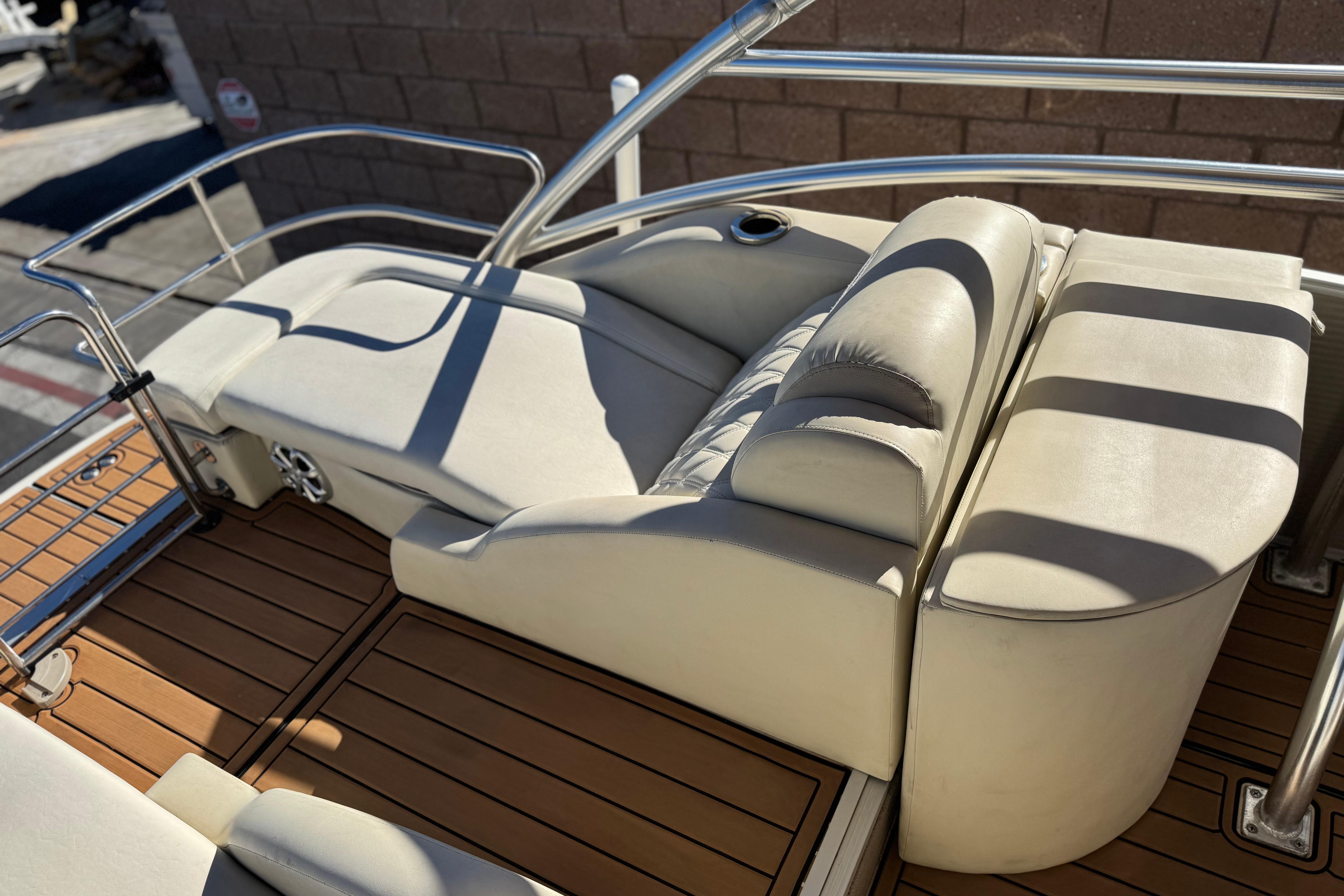 2013 Bennington 2575QCW I/O boat with beige seating and wooden deck.