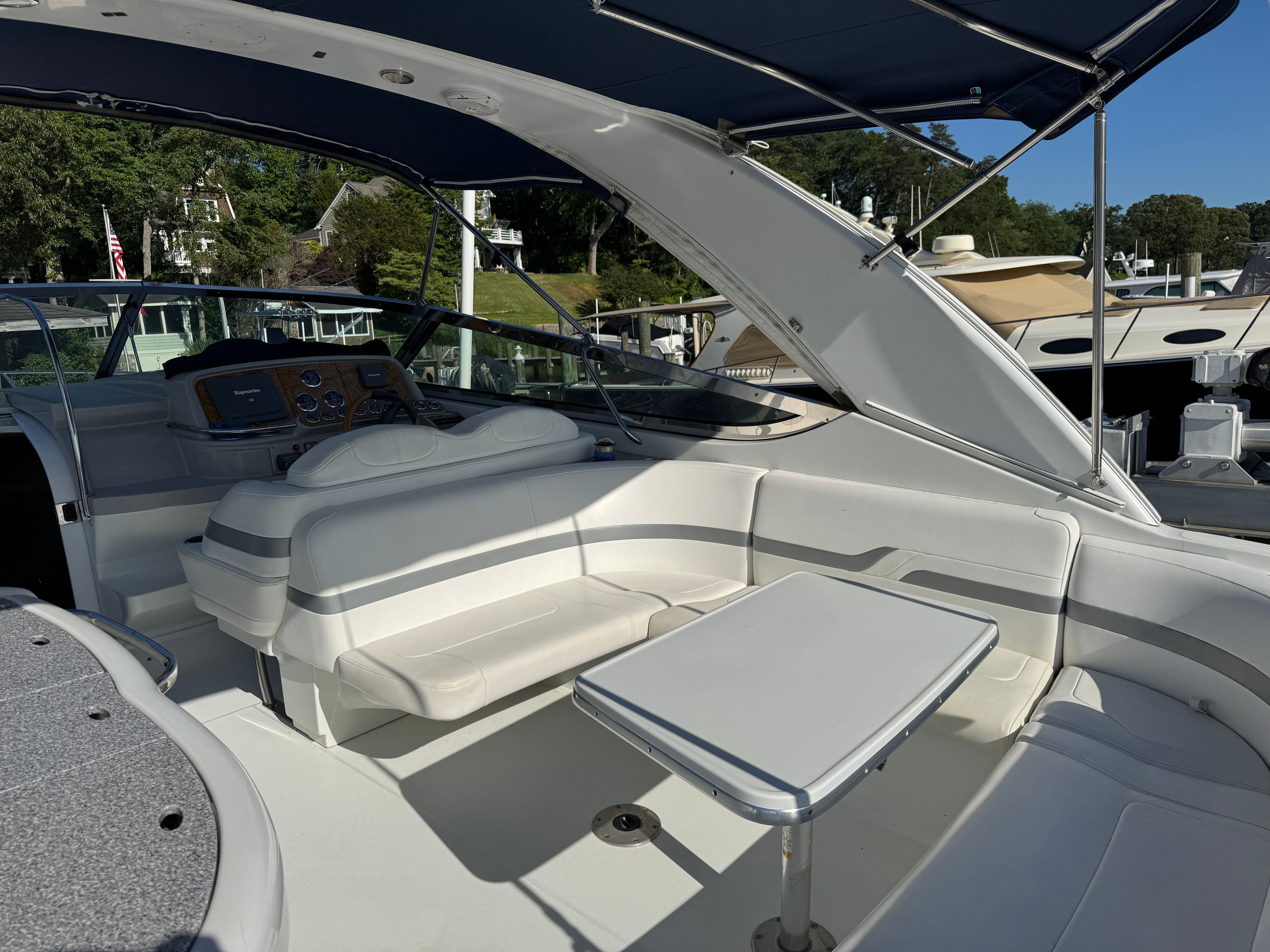 The boat features a white seating area and table under a blue canopy.