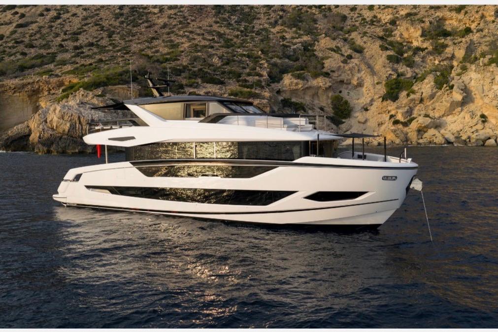 Luxury Sunseeker 82 Ocean yacht, 2026 model, anchored near rocky coastline.