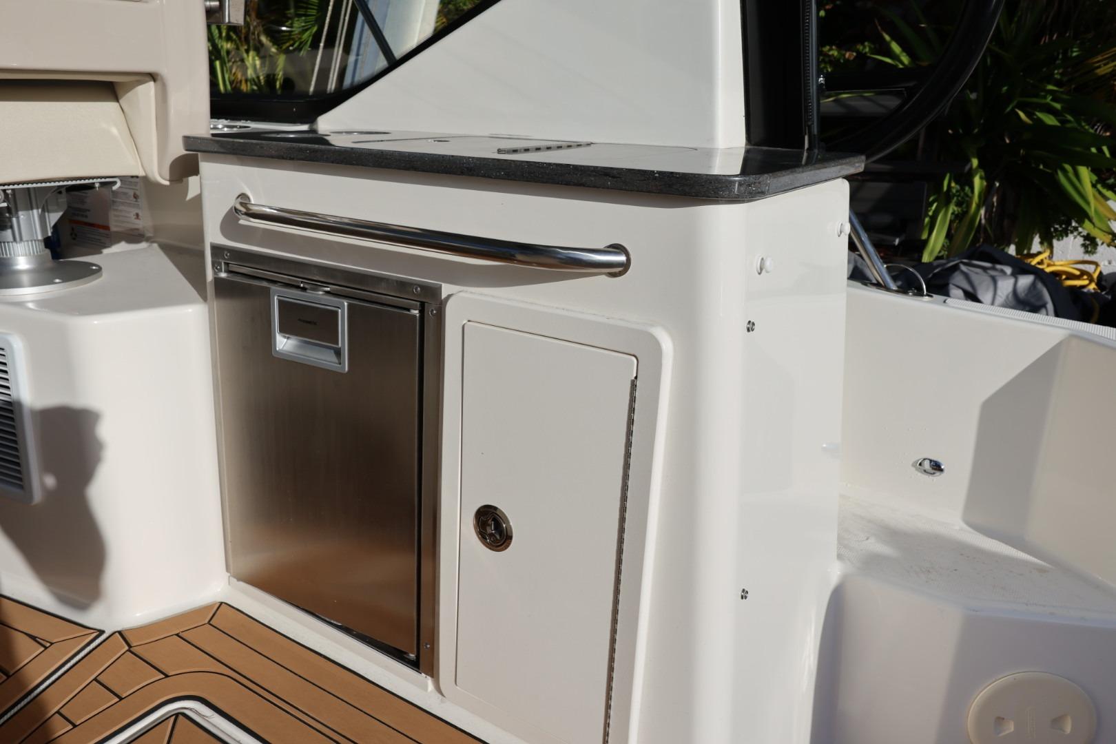 2025 Boston Whaler 325 Conquest boat interior with stainless steel cabinetry and wood flooring.