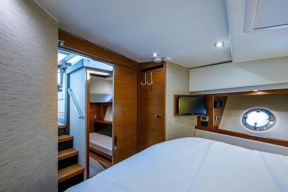 Luxurious 2017 Tiara Yacht coupe interior with modern bedroom and porthole window.