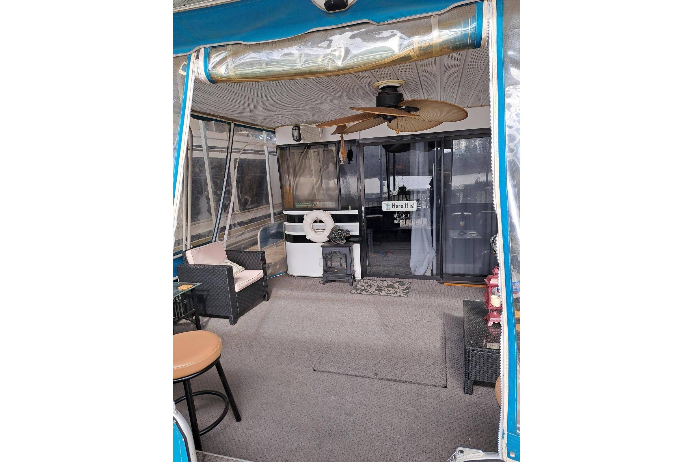 Cozy interior of a 1990 Sumerset 16 x 70 houseboat with seating and ceiling fan.