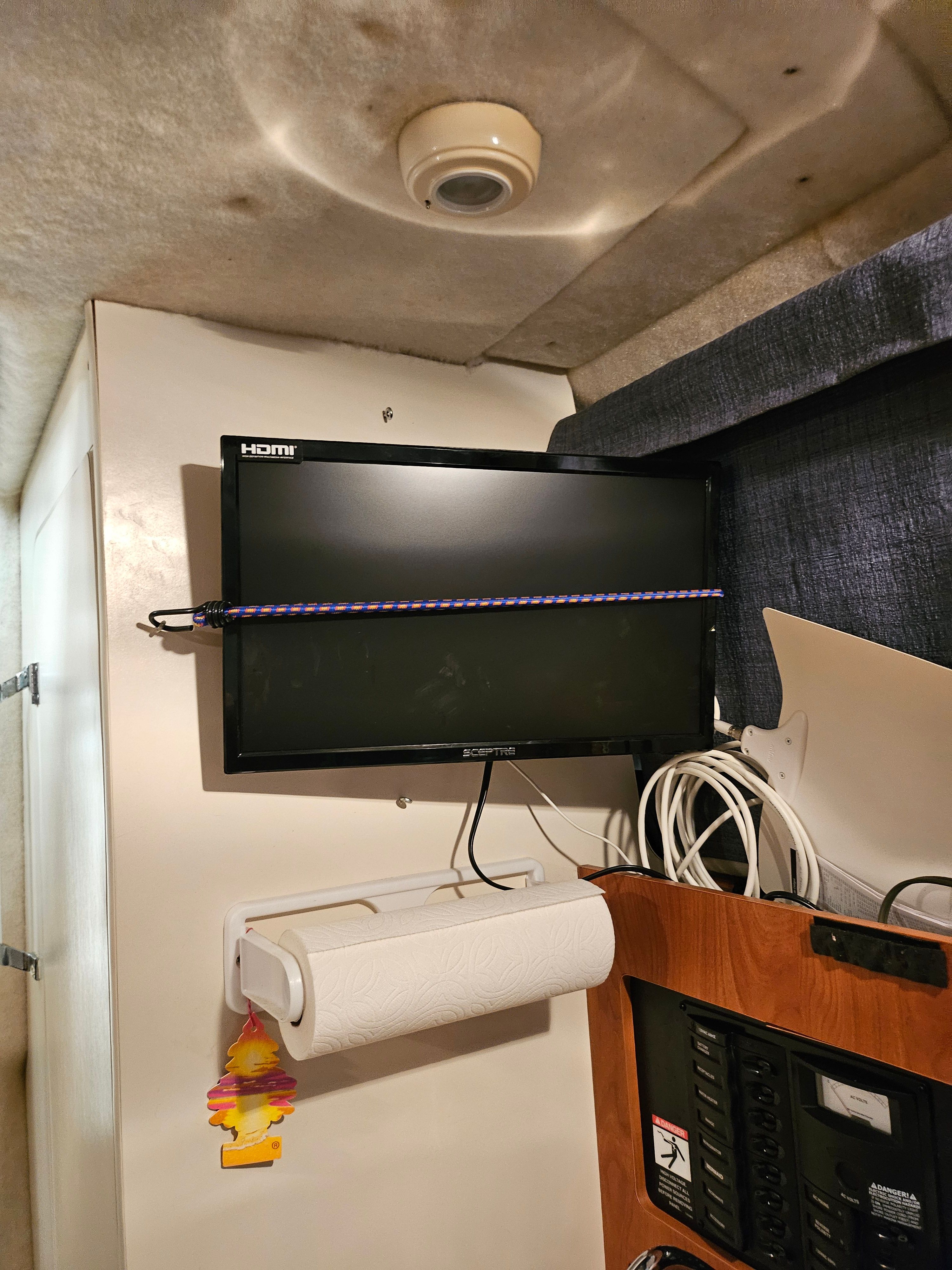 Interior of a Bayliner 242 Ceara with a TV and paper towel holder.