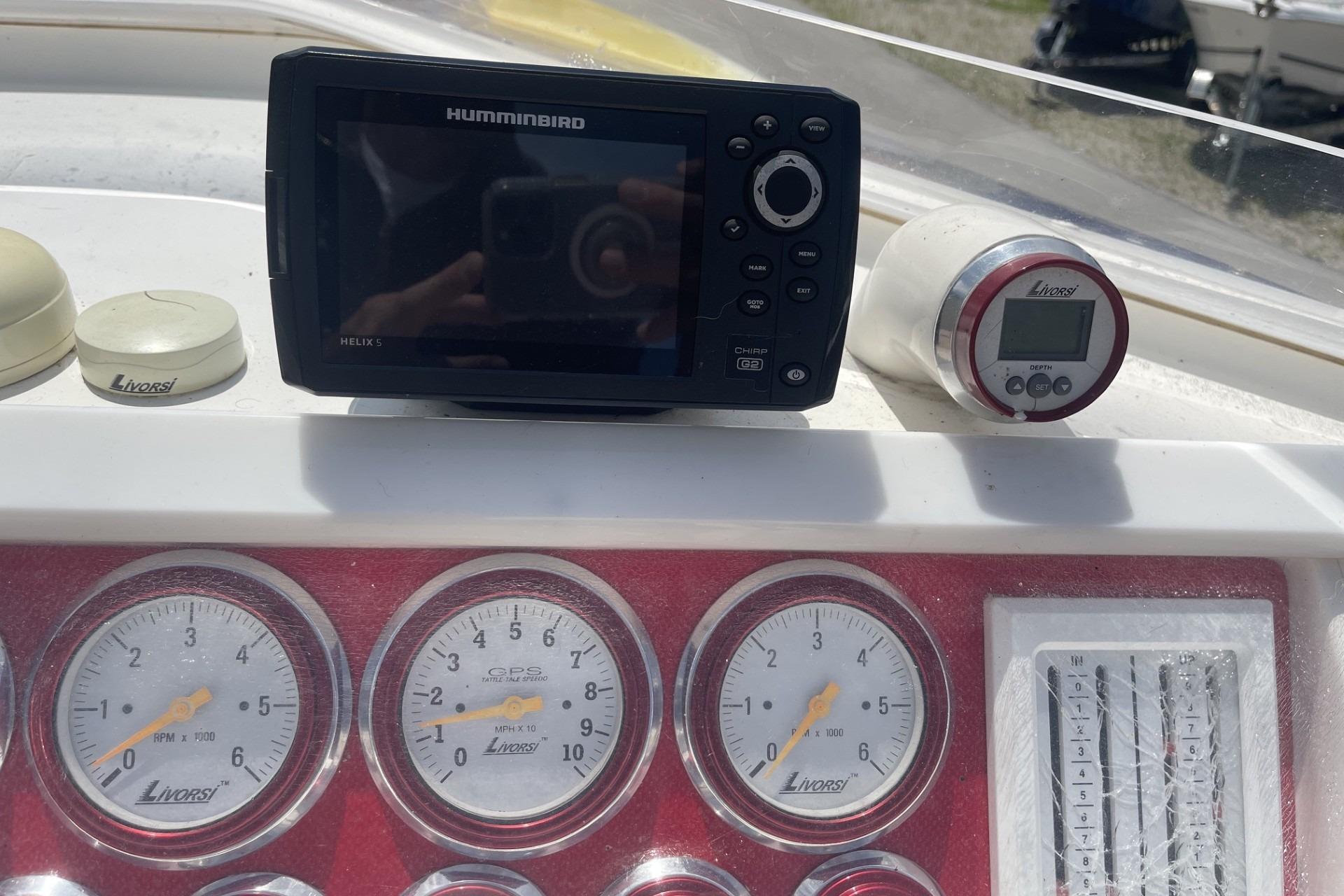 Dashboard of a 2006 Sonic 386 boat with Humminbird Helix 5 and Livorsi gauges.